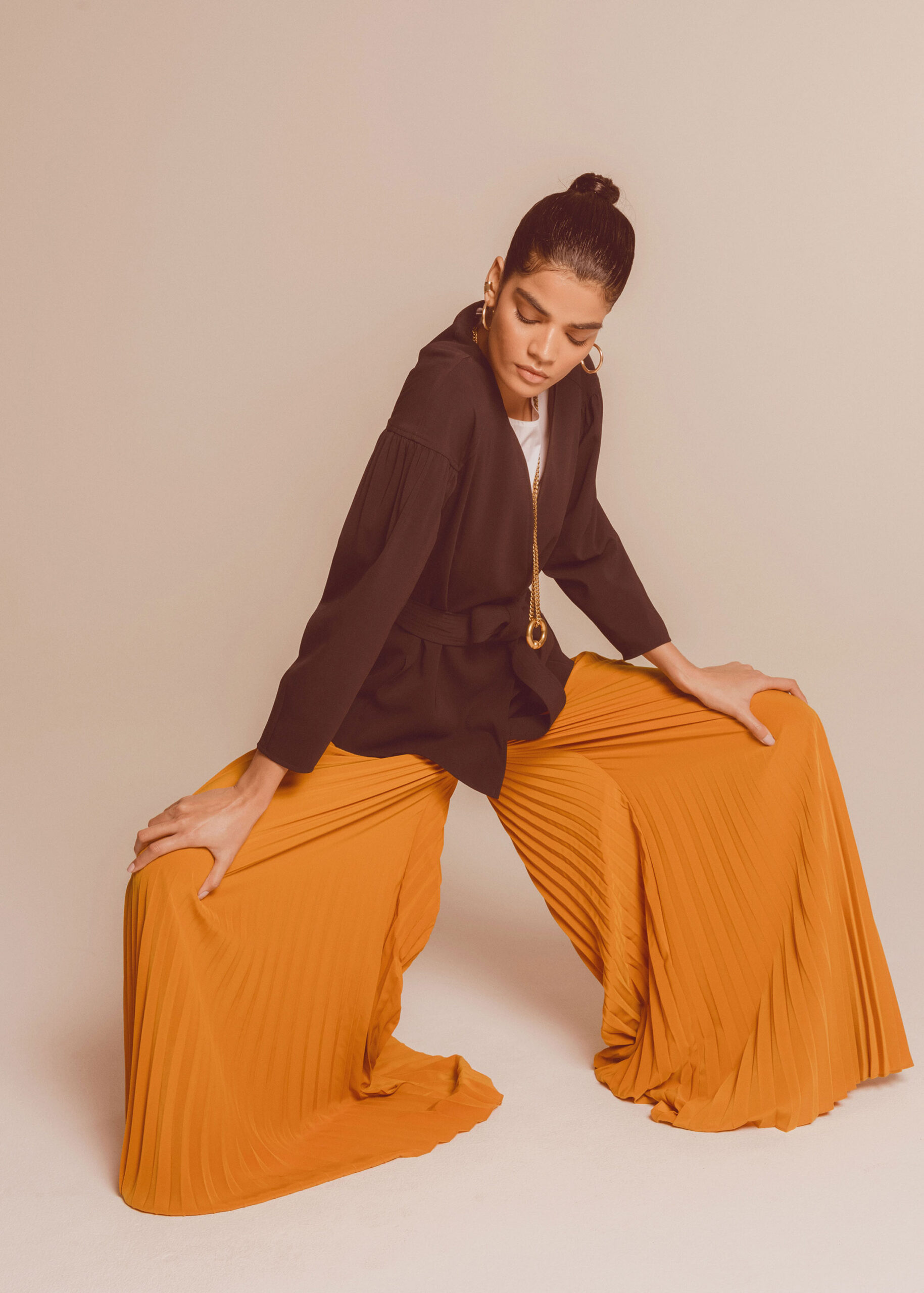 black jacket and orange pleated pants