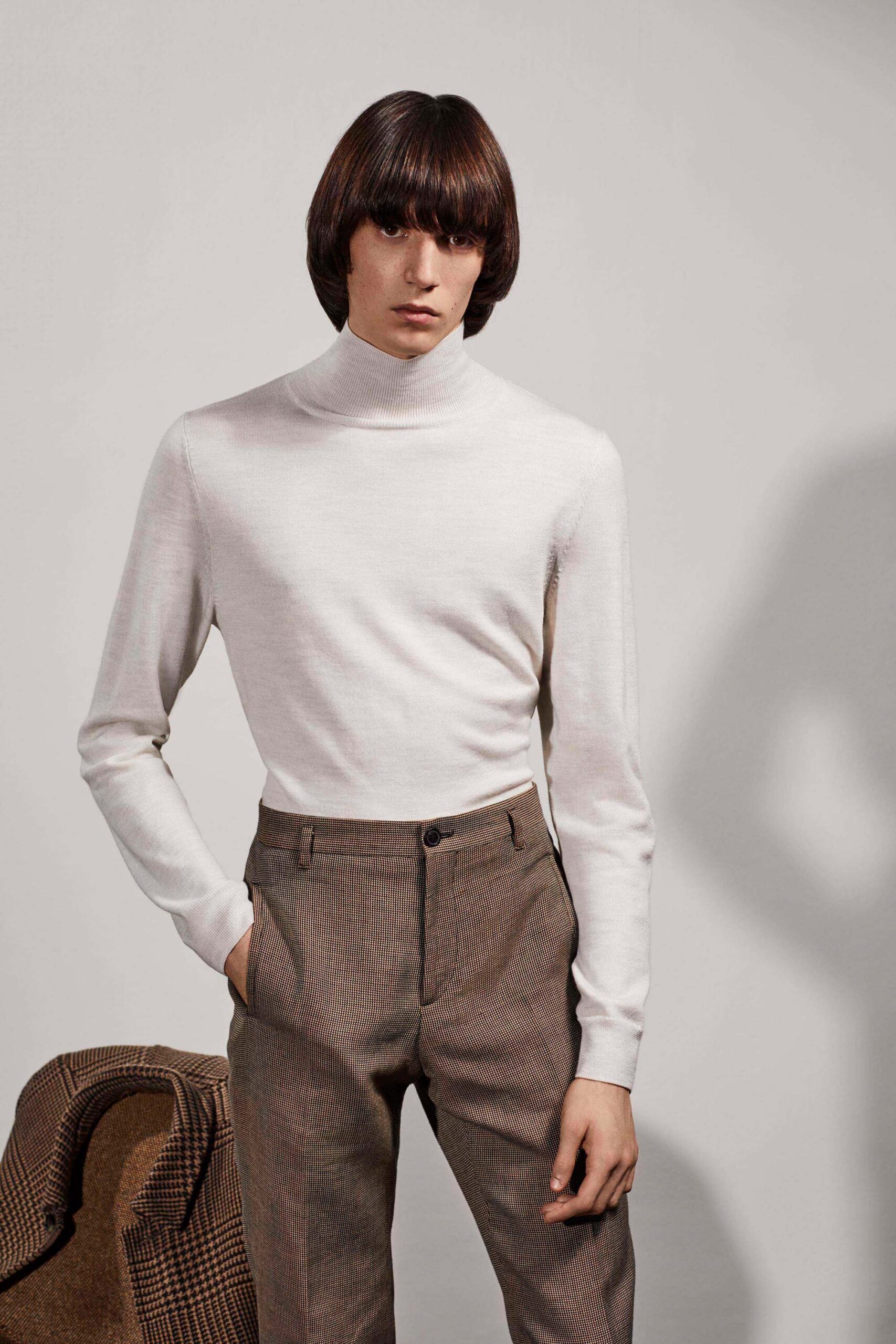 fitted white turtleneck top and tailored brown pants