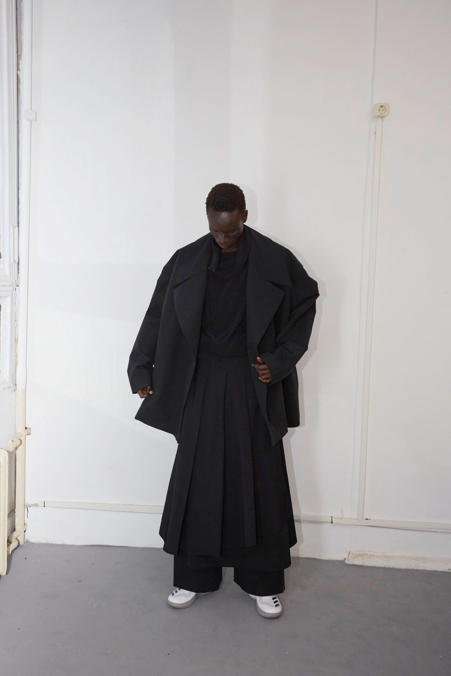 oversized black coat with pleated skirt