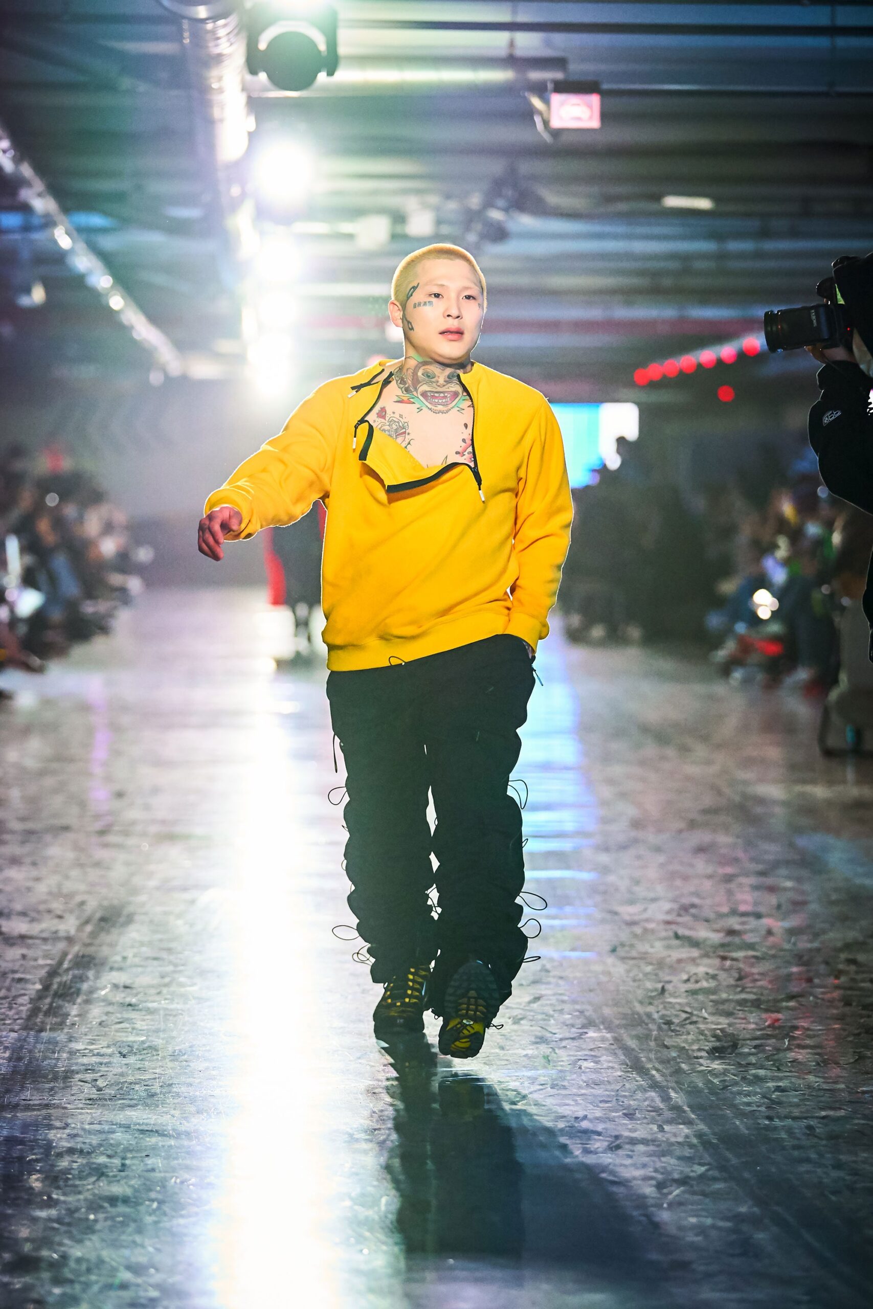 A relaxed yellow cotton hoodie paired with black pants featuring a zippered detail.