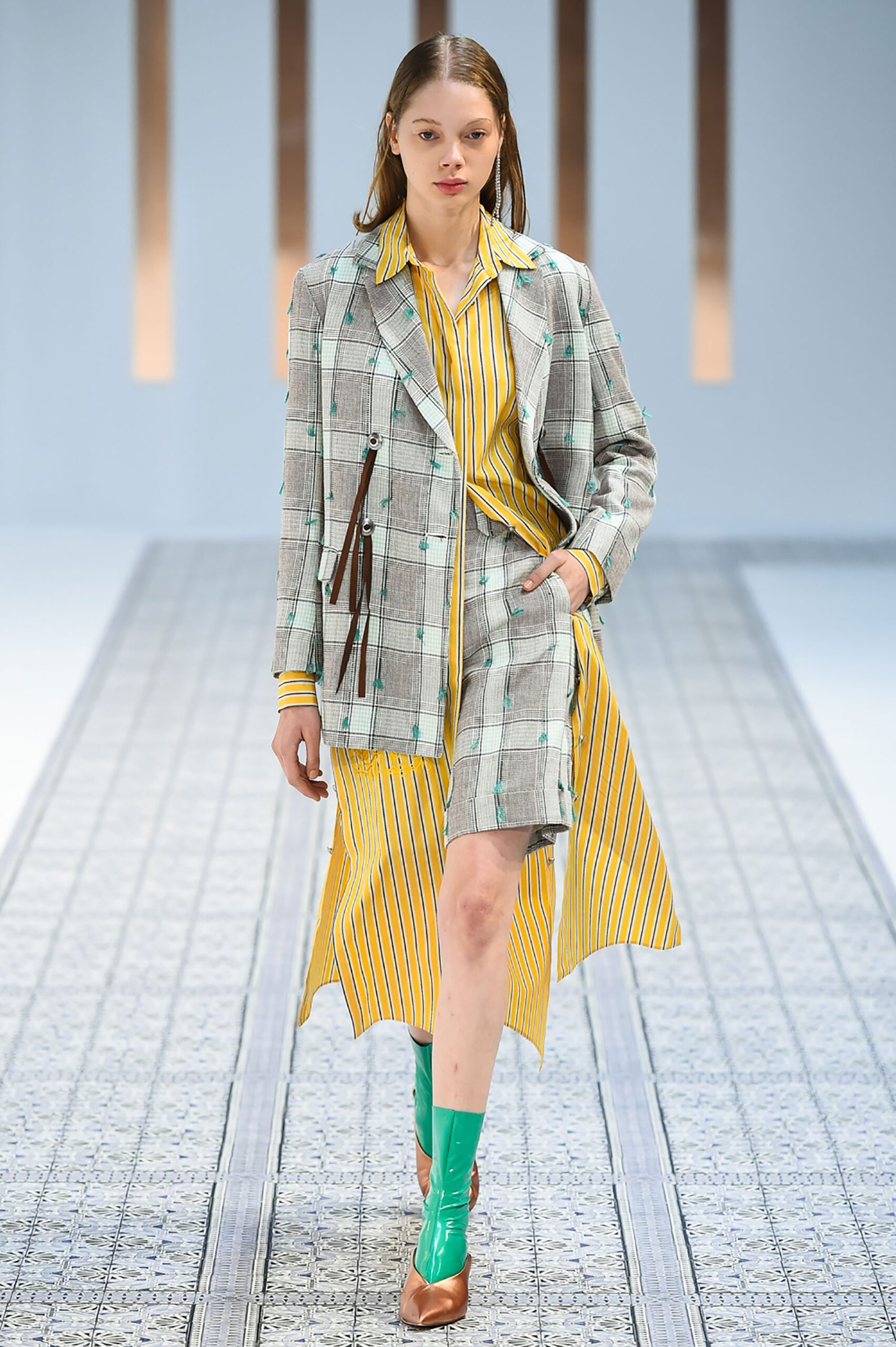 A fitted gray checked jacket dress with long sleeves and a collared neckline, featuring striped details.