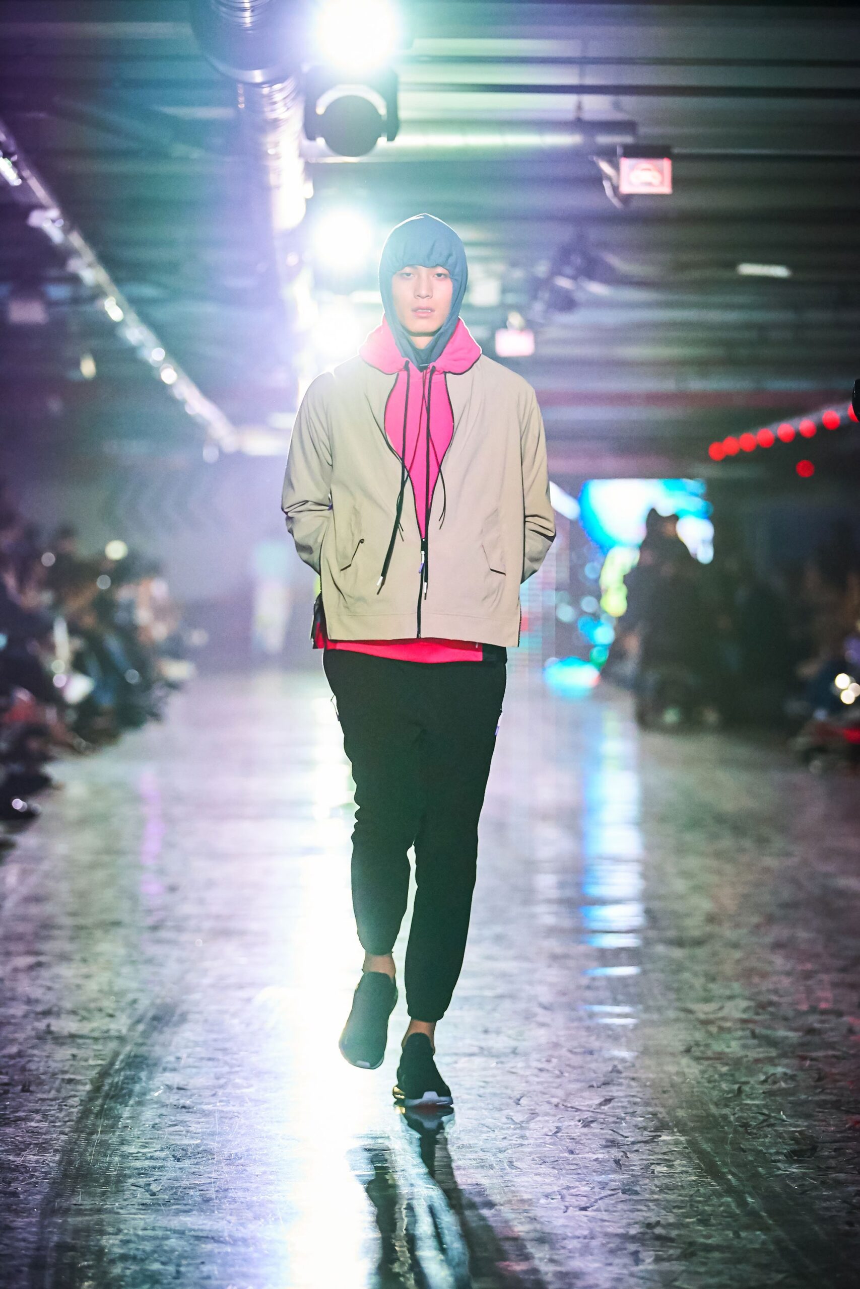 A relaxed beige hooded jacket paired with black pants, featuring a zippered design.