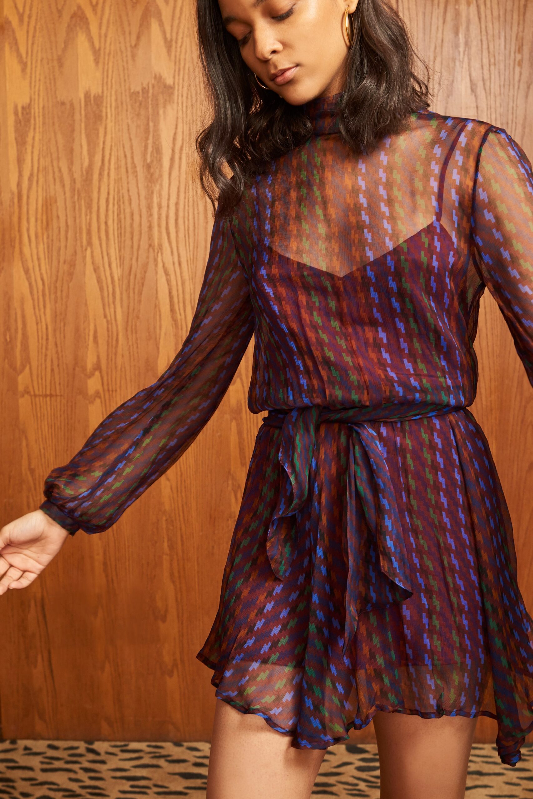 A relaxed purple sheer long-sleeve dress with a high neckline and tiered design.