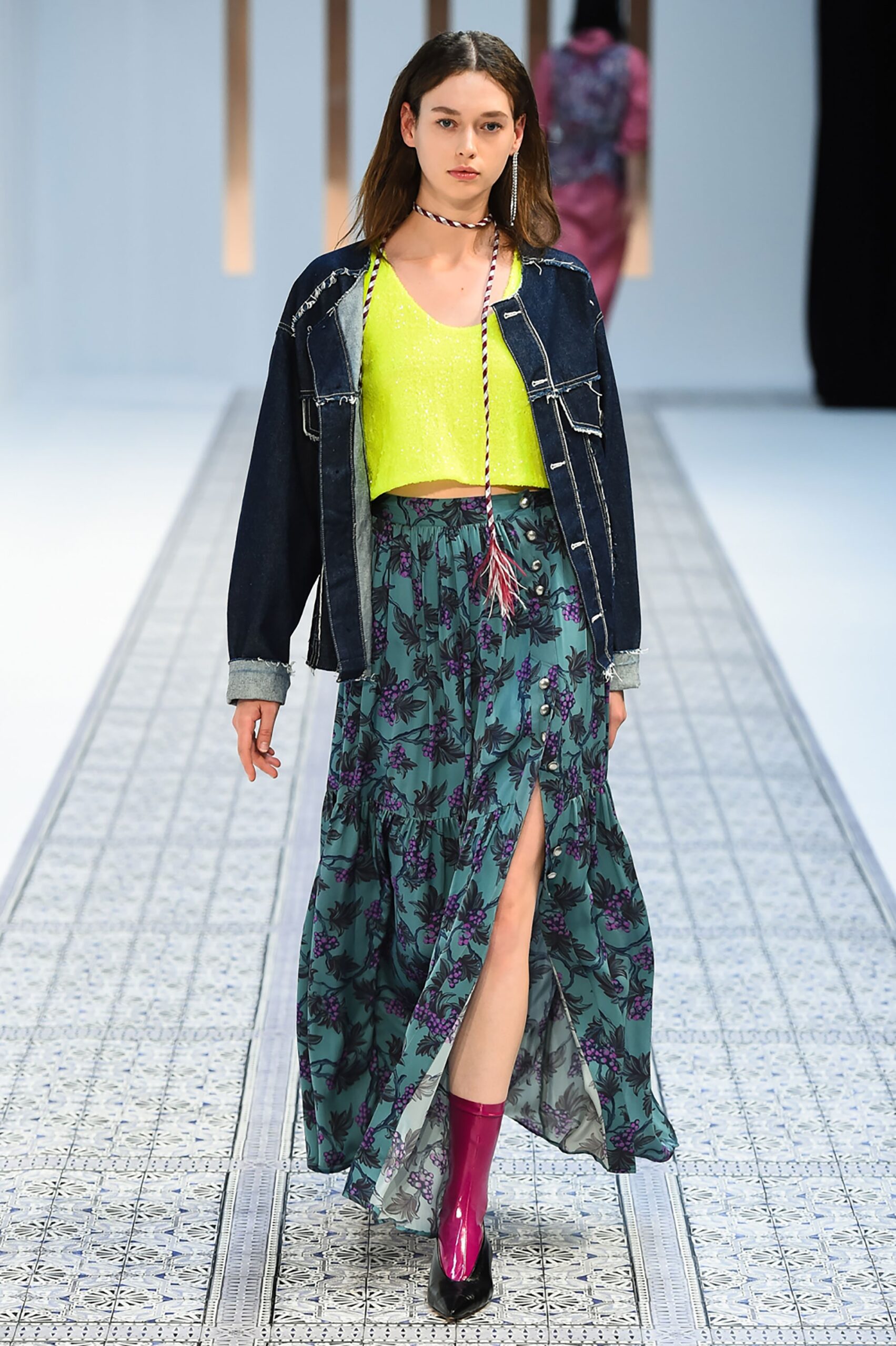A relaxed denim jacket paired with a high-waisted printed skirt featuring a flared silhouette.