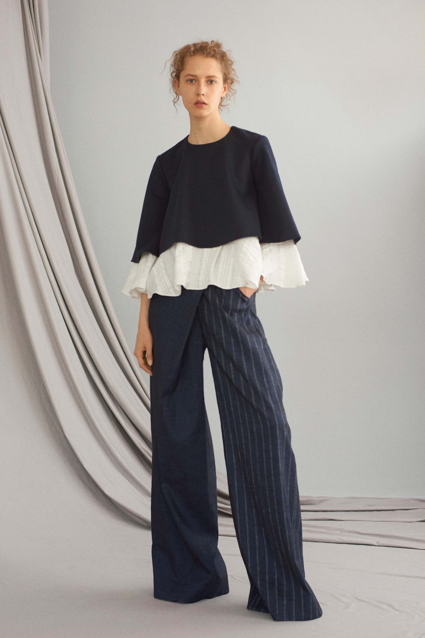navy and white ruffled top with blue striped pants