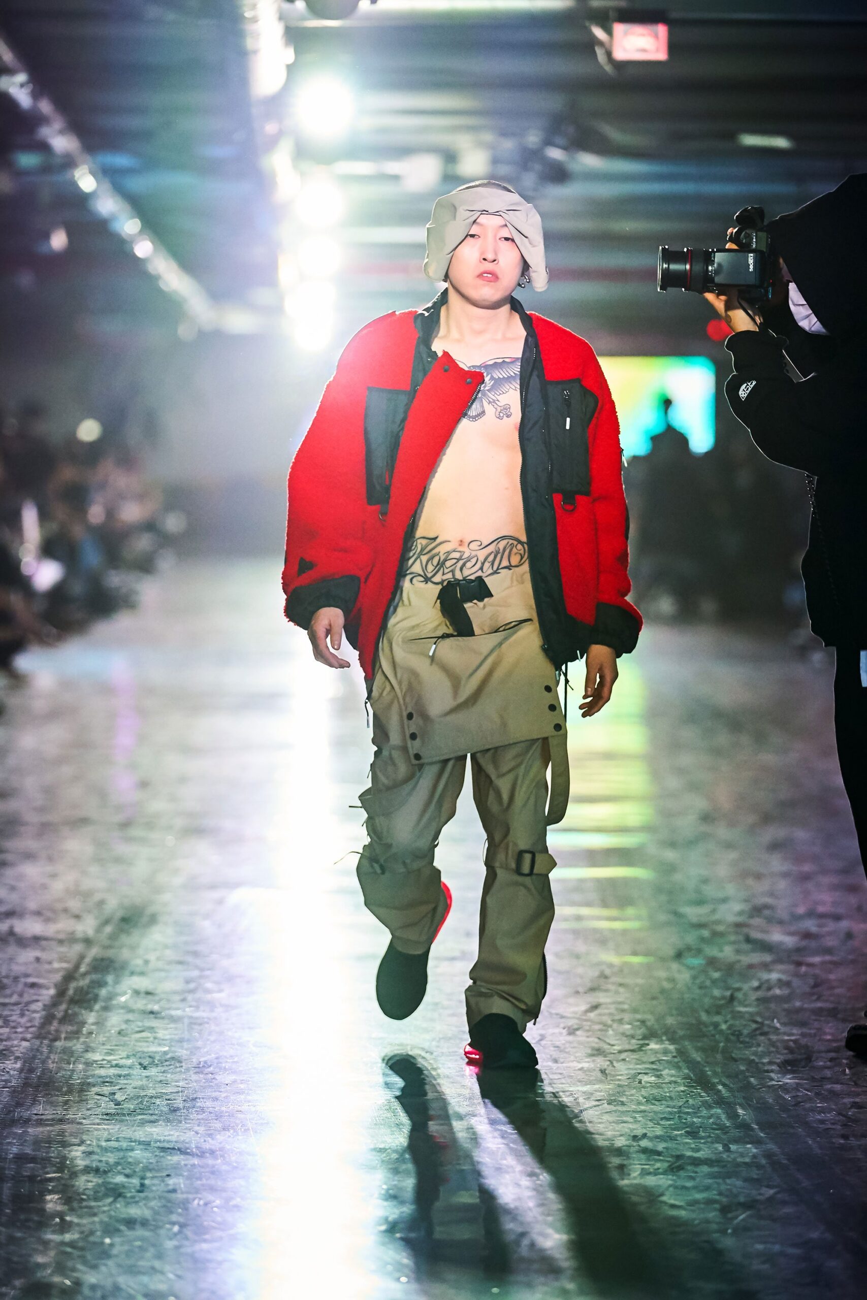 A relaxed red cotton jacket with a collared design paired with beige pants featuring a zippered detail.