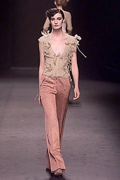 beige ruffled top with orange pants