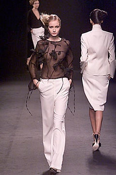 black silk ruffled blouse and white tailored pants