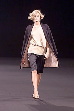 black coat beige top black shorts