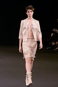 beige silk fitted jacket and white fringed skirt
