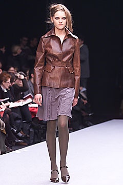brown leather fitted jacket and gray pleated skirt