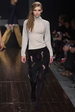 beige fitted knit top and black layered skirt