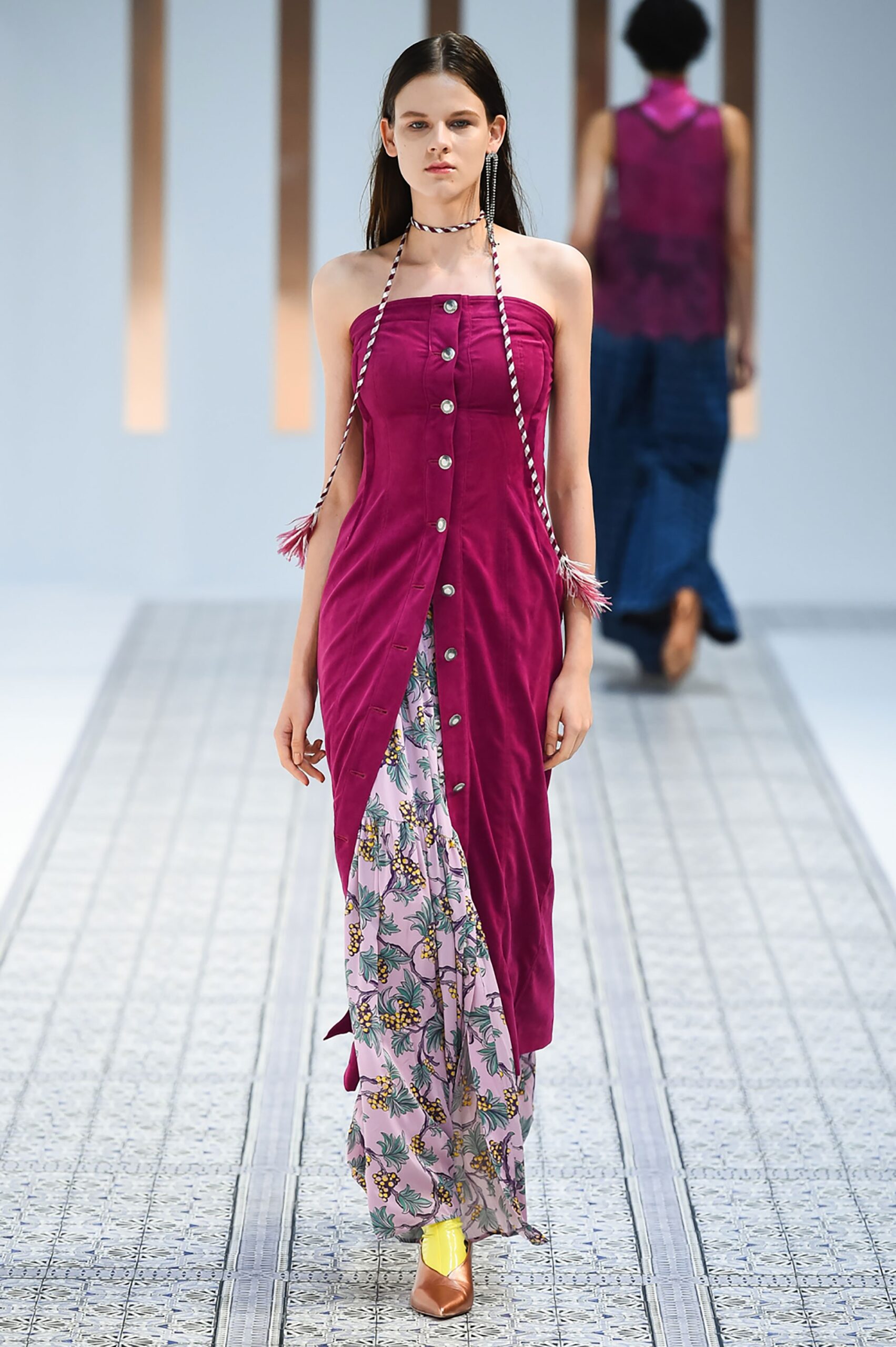 A fitted sleeveless dress in purple and pink with a V-neckline and tiered design.