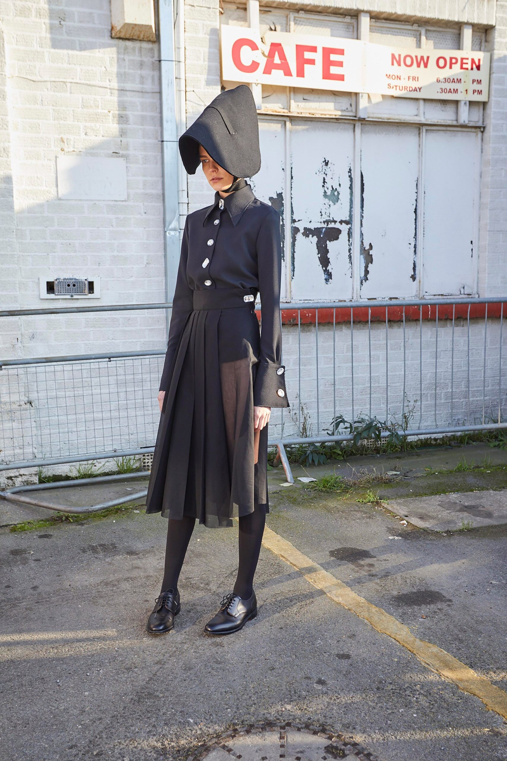 black pleated midi dress with structured hat