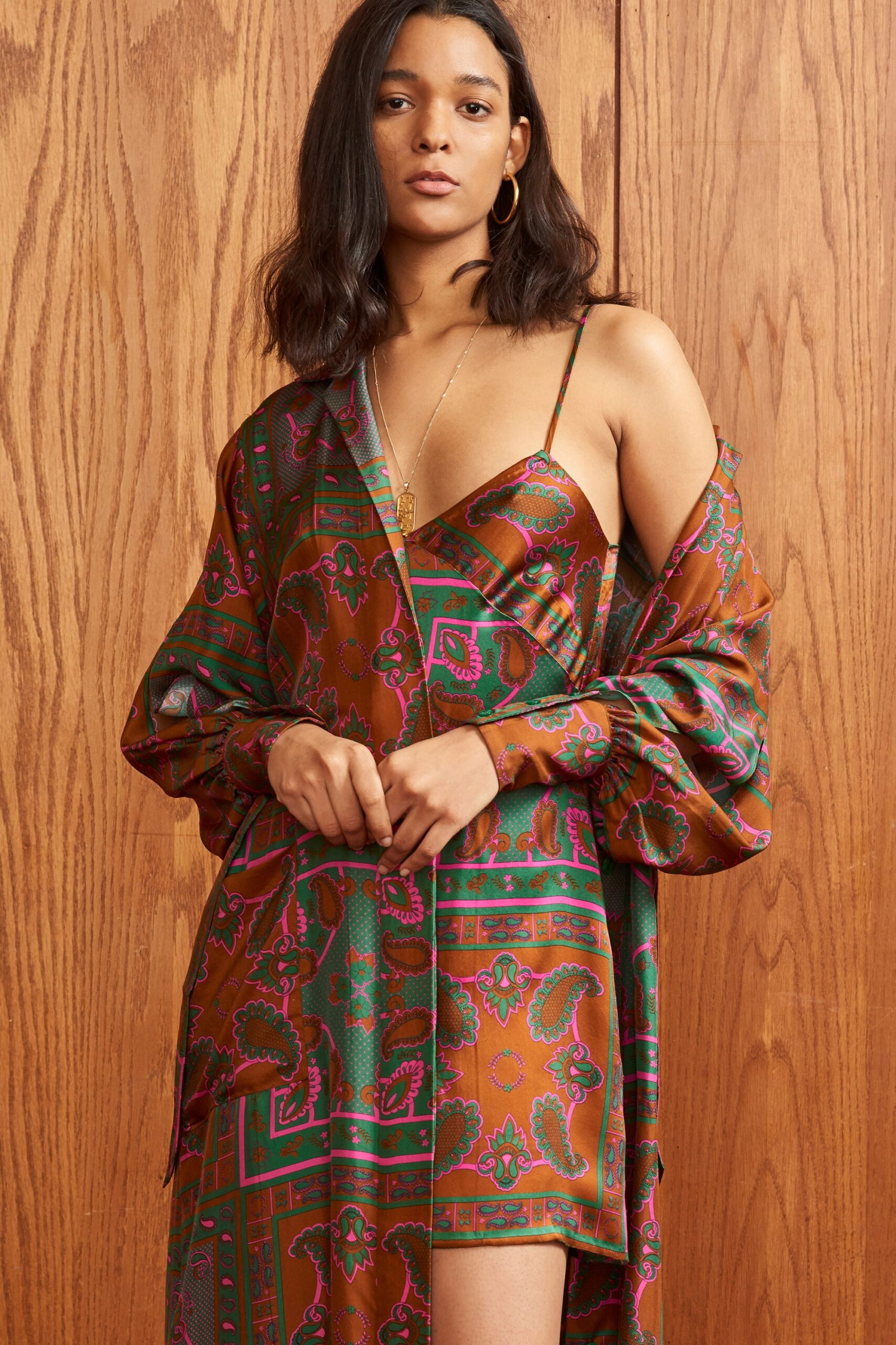 A relaxed brown and green printed dress with a sleeveless design and V-neckline.
