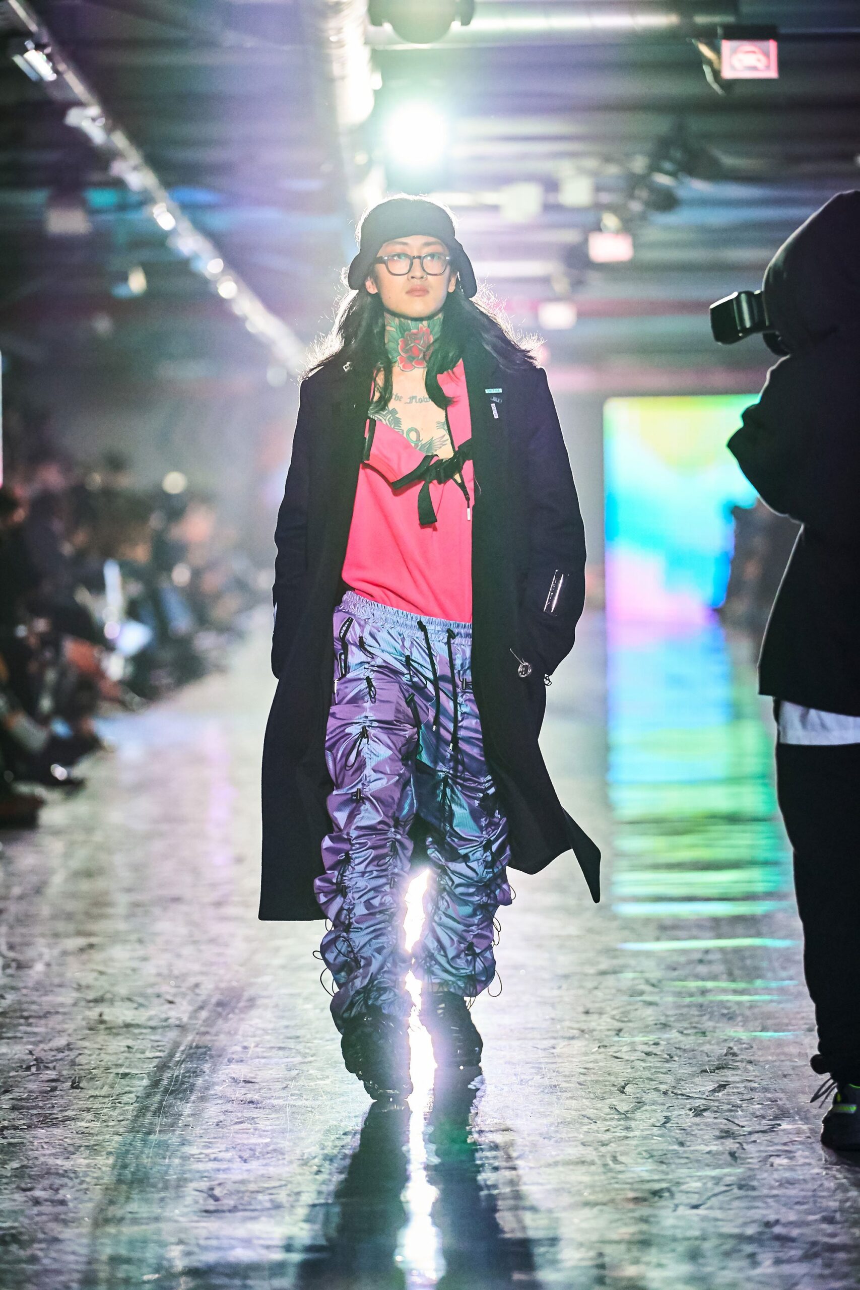 A relaxed black coat layered over a pink v-neck top.