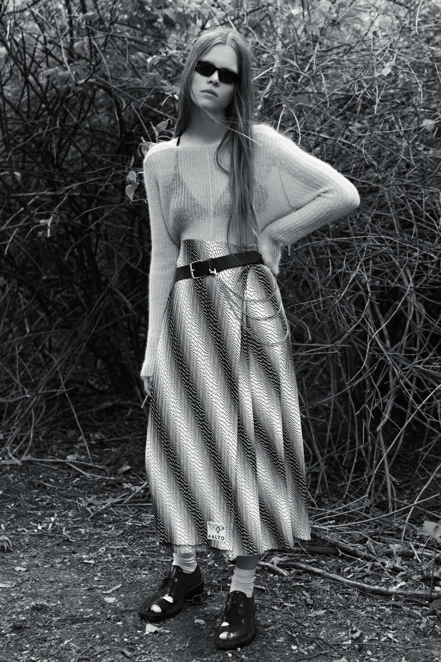 white wool sweater and black pleated skirt