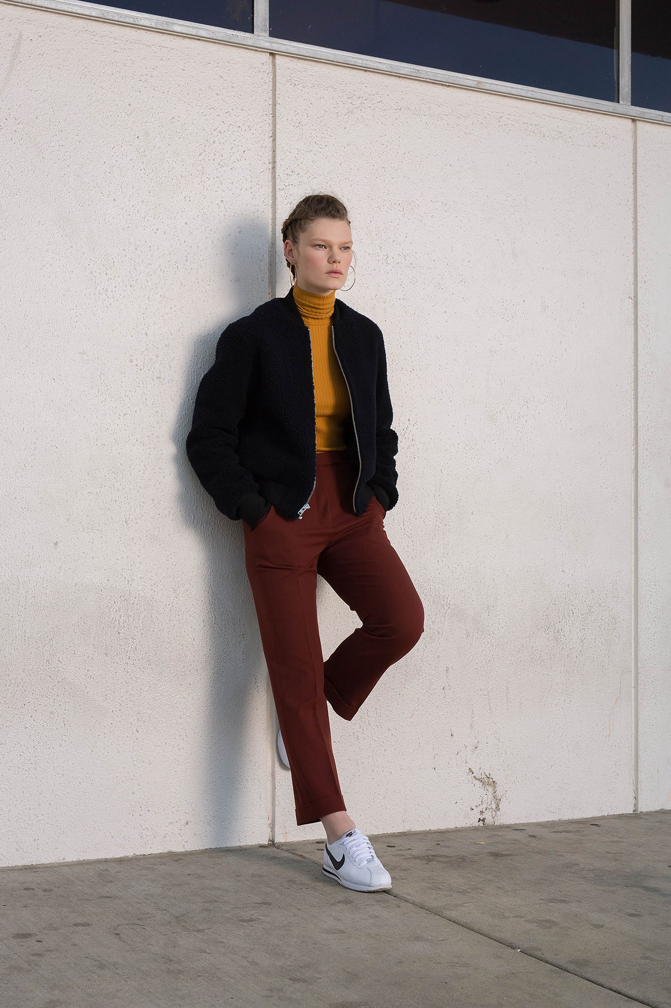 black jacket yellow turtleneck red pants