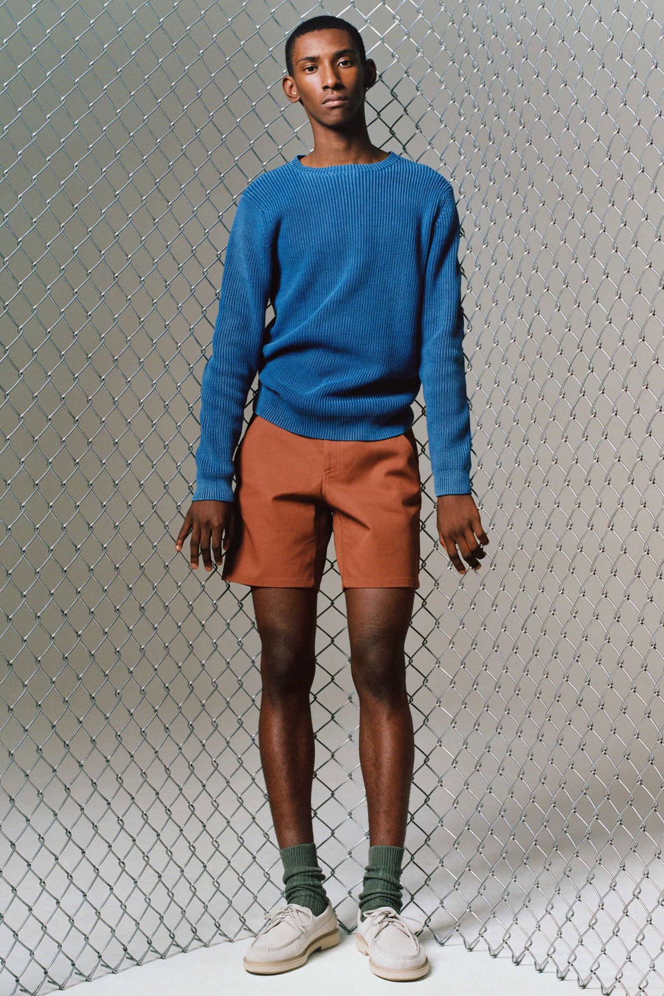 blue fitted sweater and brown shorts