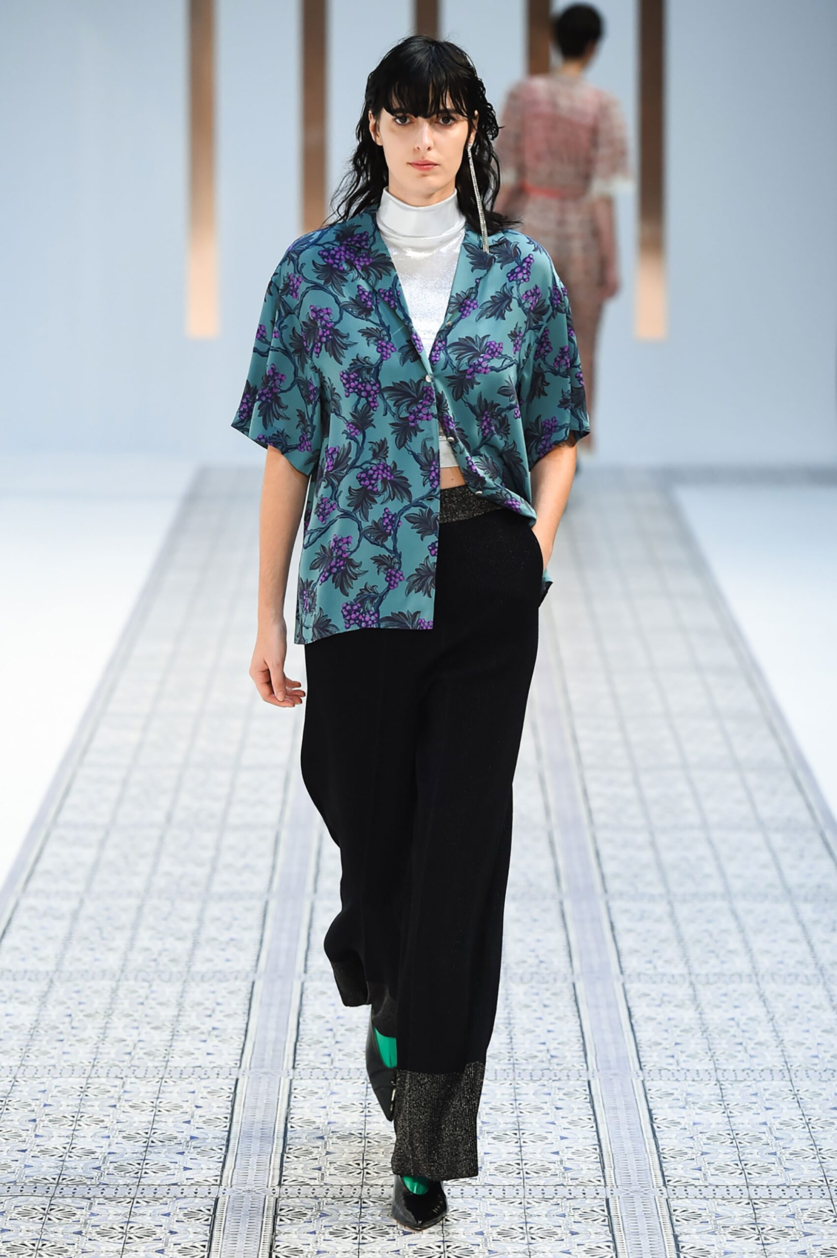 A relaxed blue printed shirt with short sleeves paired with wide-leg black pants.