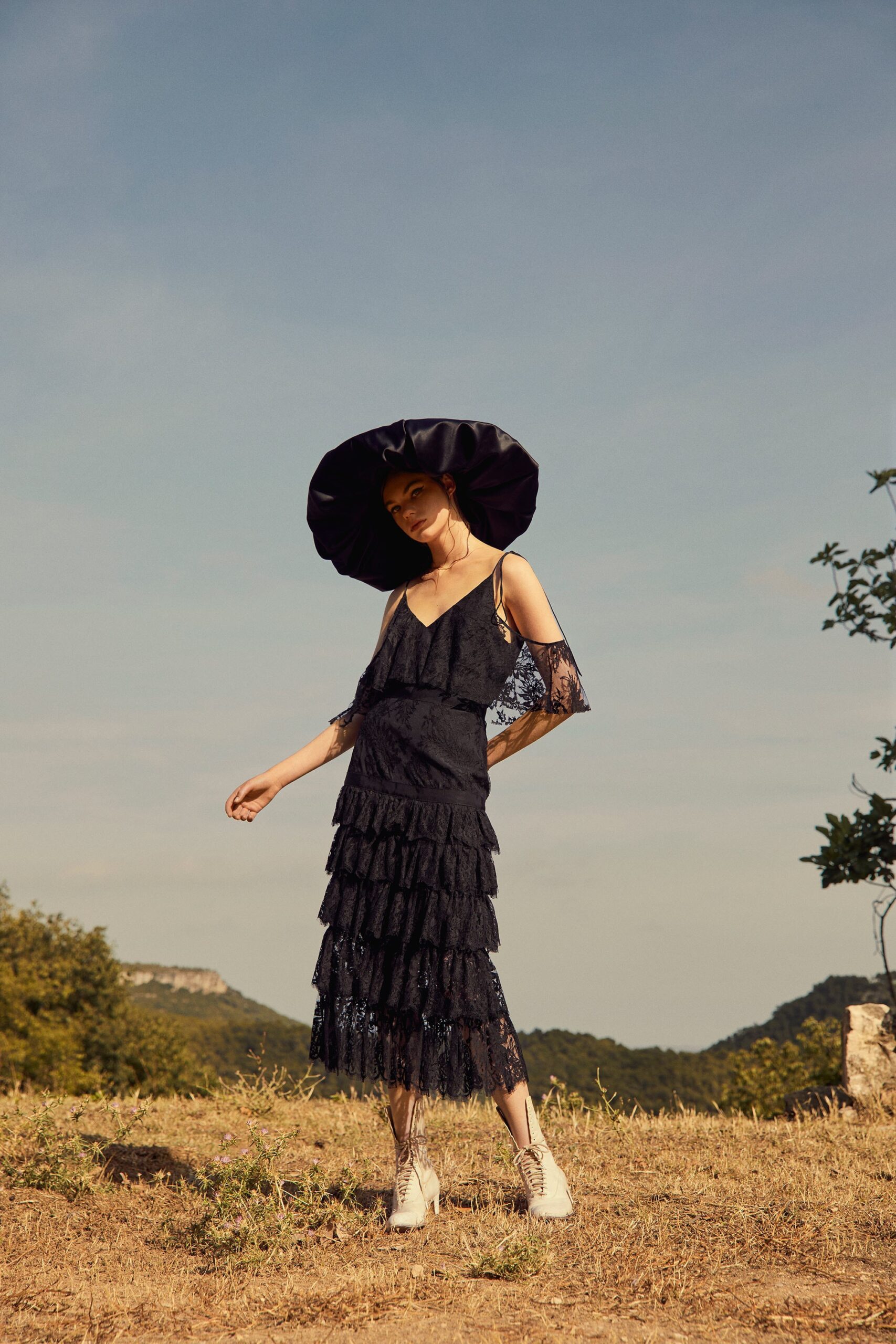 black lace tiered midi dress and wide-brim hat