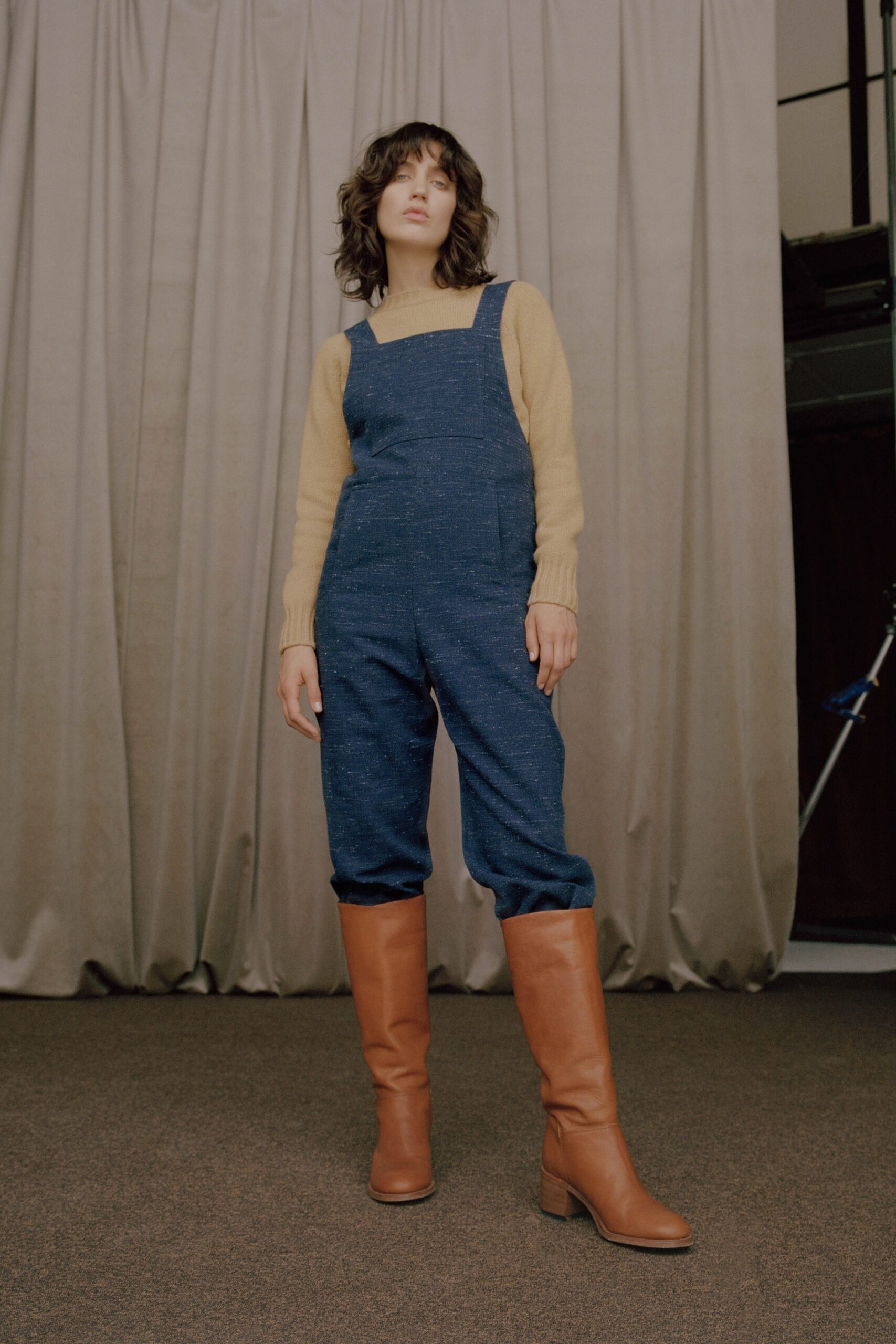 blue denim overalls with beige sweater