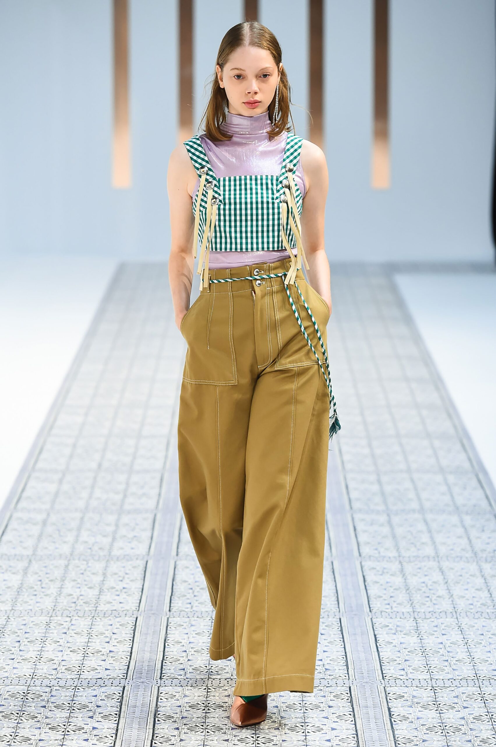 A relaxed checked sleeveless top paired with beige wide-leg pants.