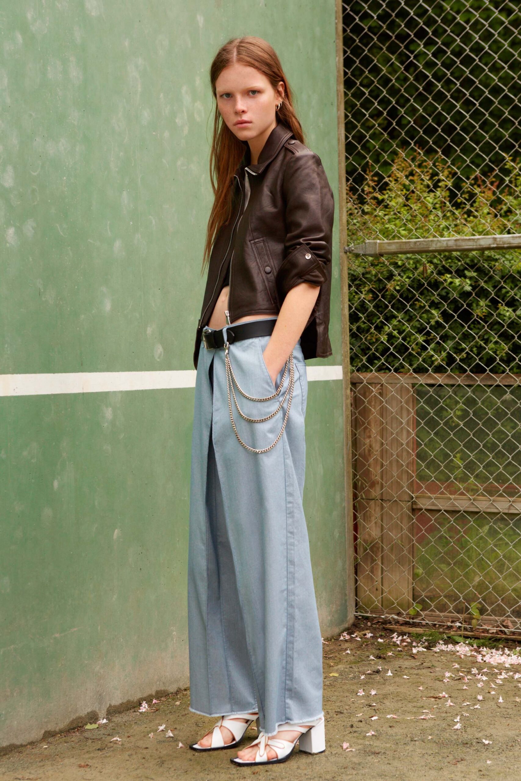 black leather fitted jacket and blue wide-leg pants