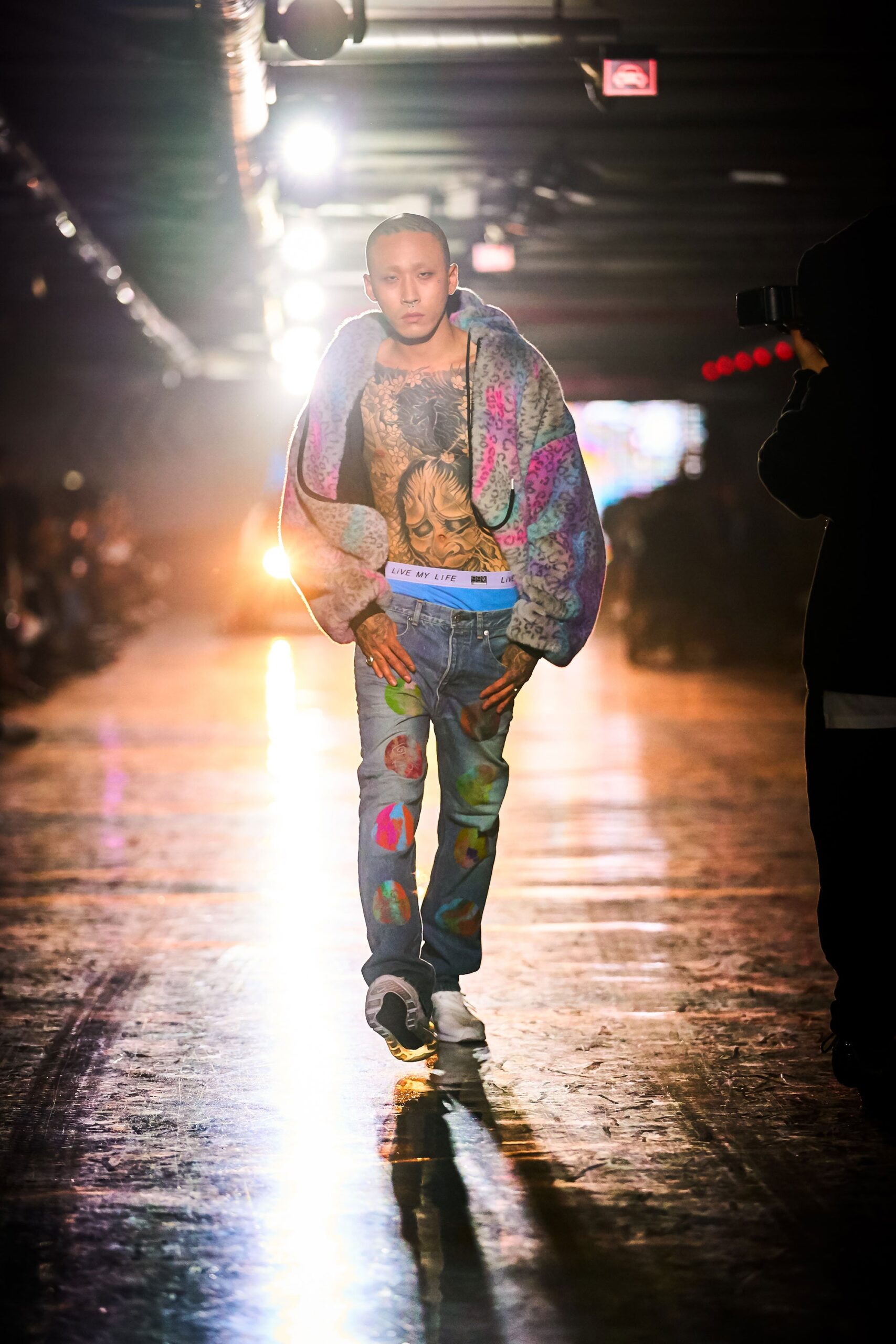 A relaxed-fit multicolor jacket with printed details paired with blue denim pants.