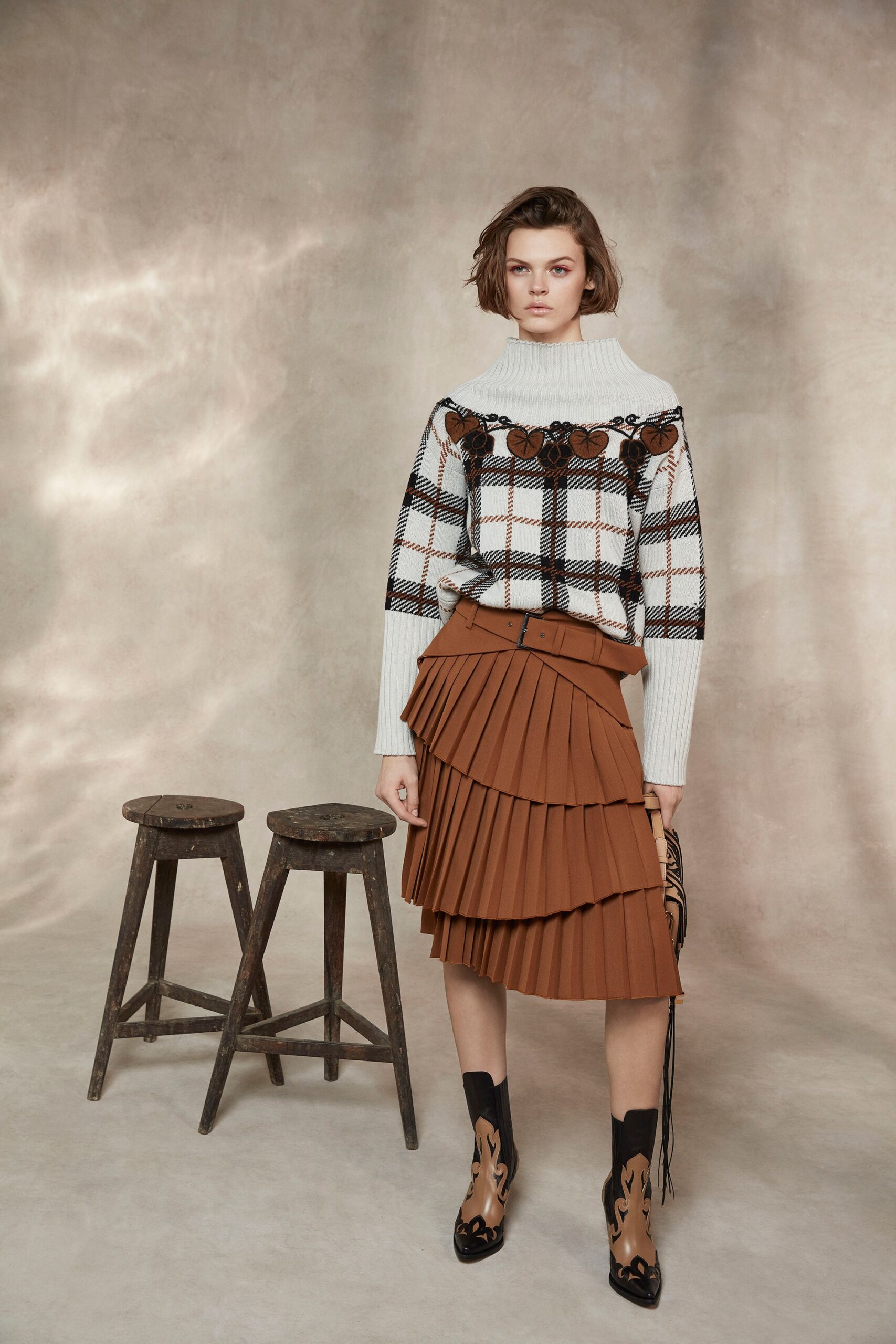 fitted white sweater and brown pleated skirt