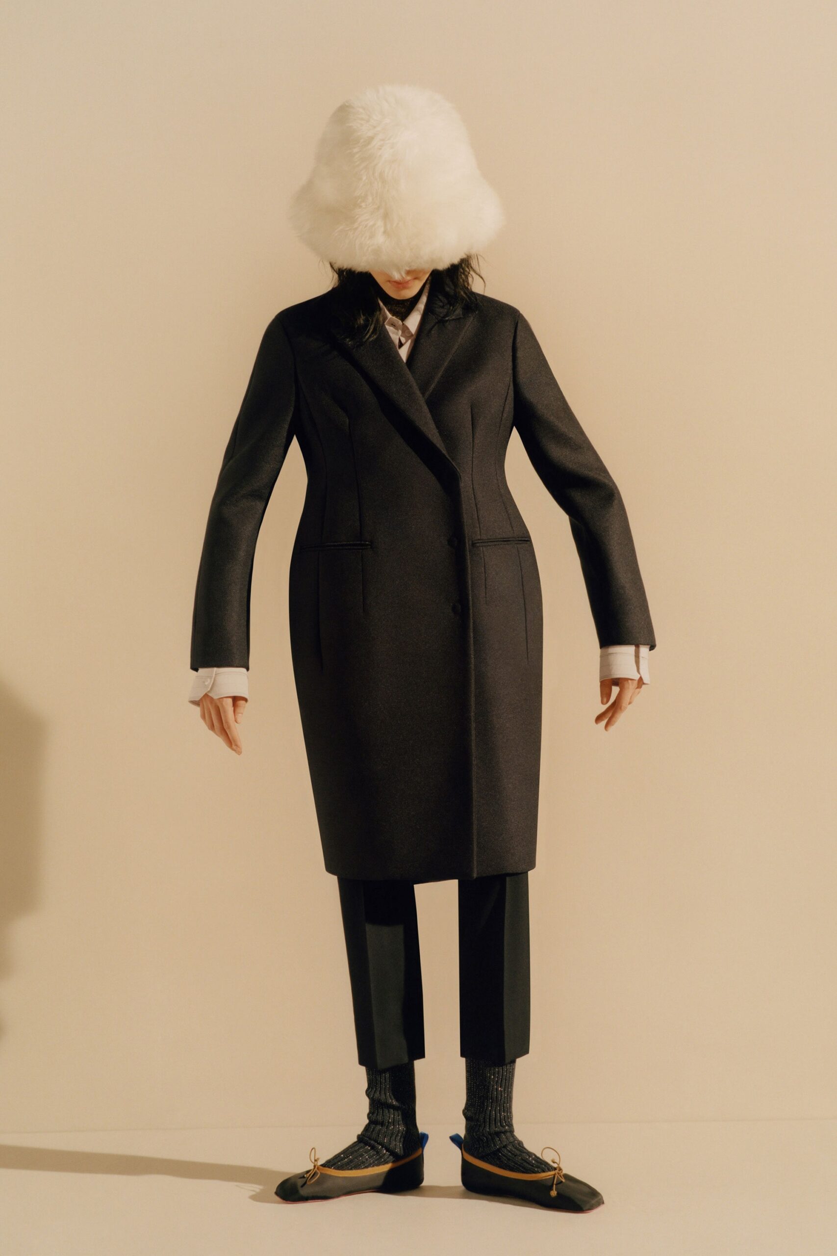 black tailored coat with white fur hat