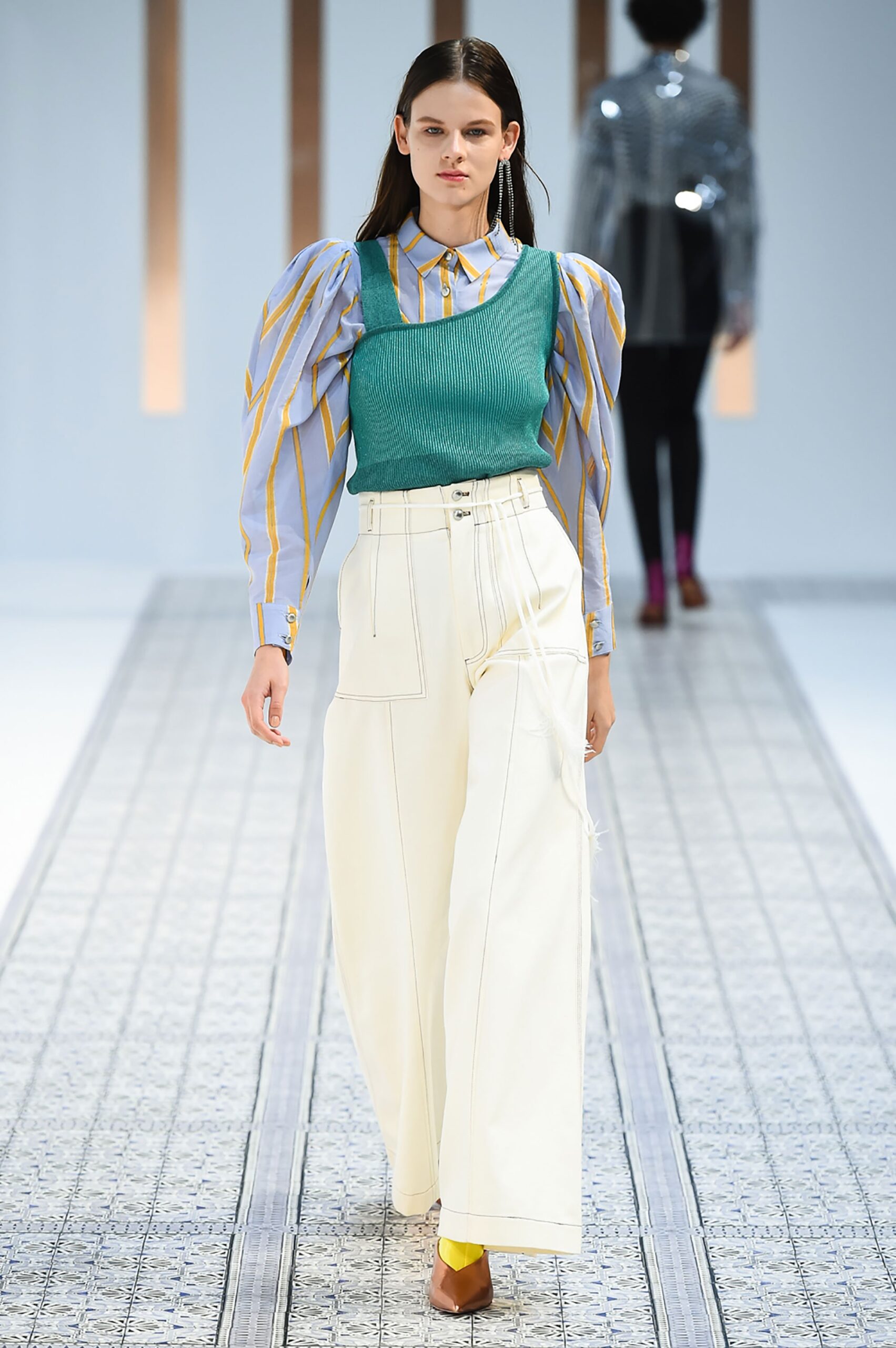 A relaxed long-sleeve striped green top paired with wide-leg white pants.