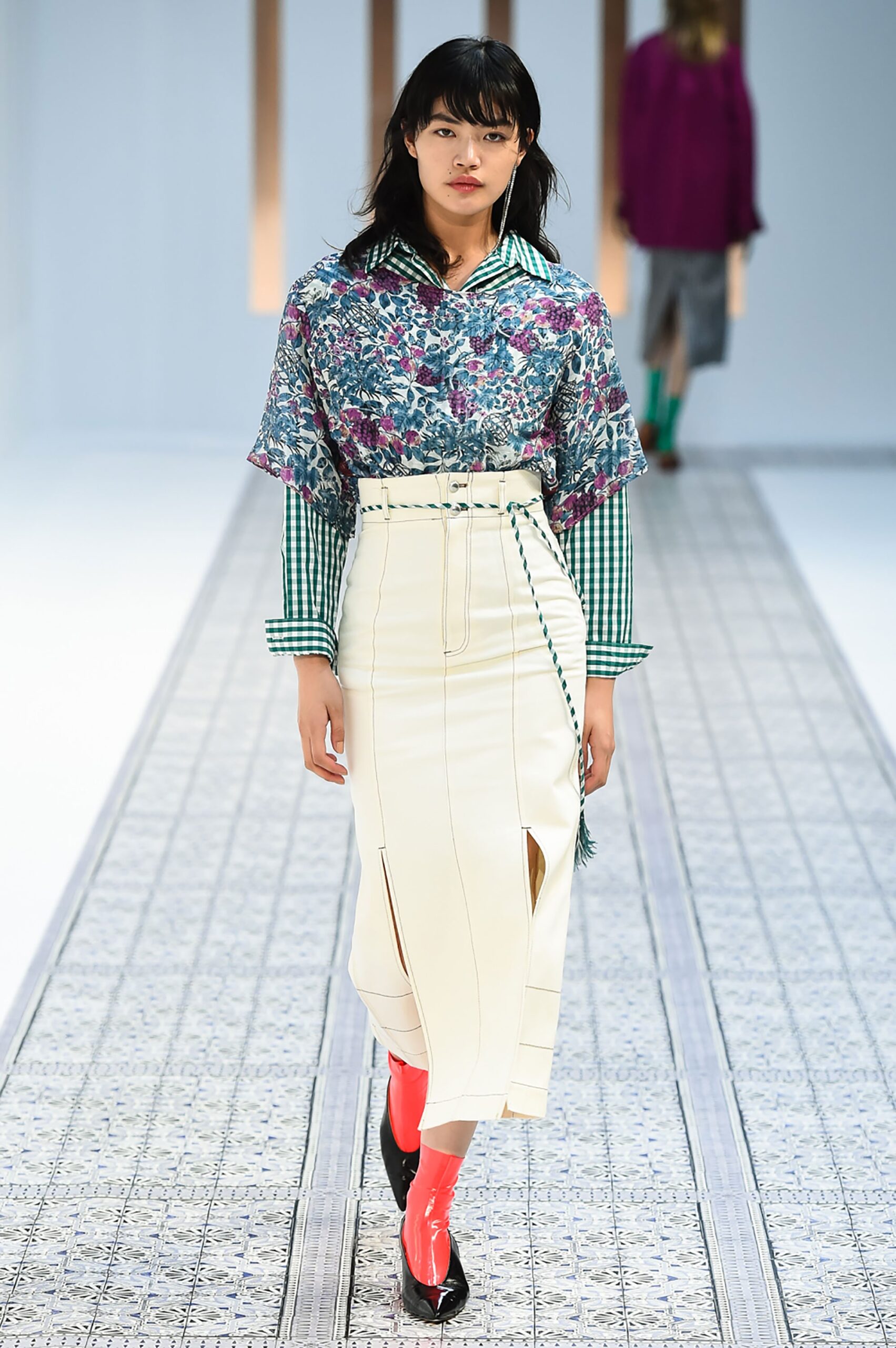 A fitted white skirt paired with a long-sleeve printed top featuring a collared neckline.