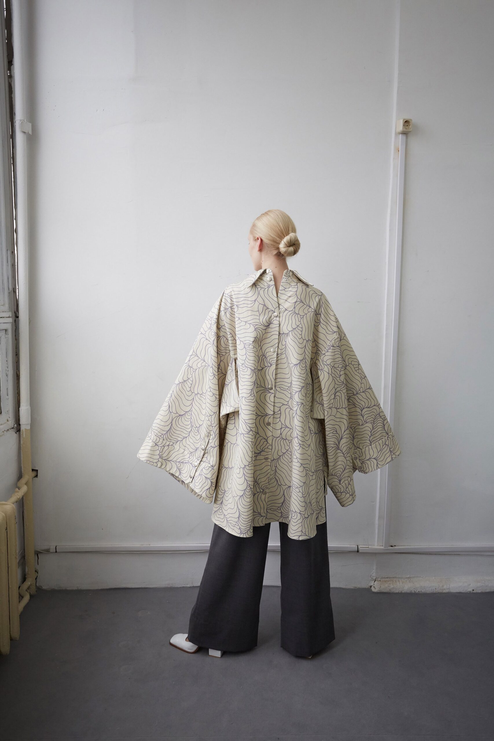beige silk printed cape with black pants