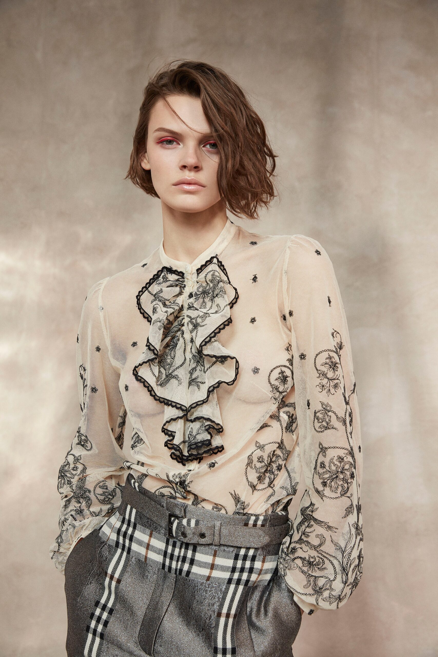 beige silk ruffled blouse and gray tailored pants