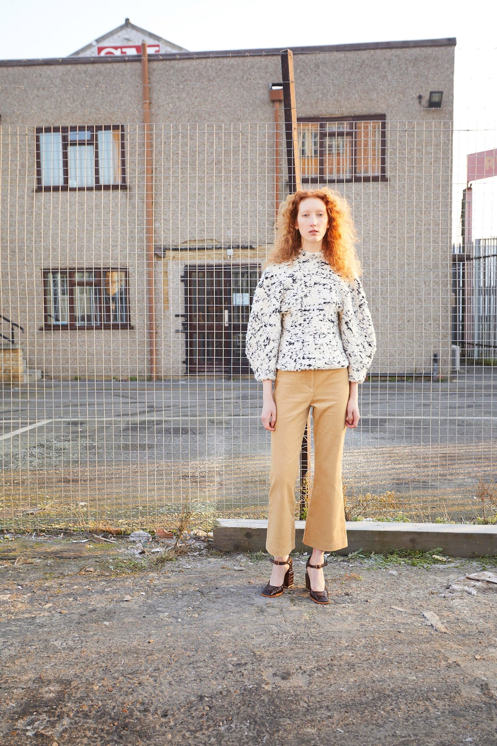 fitted white ruffled top with beige flared pants