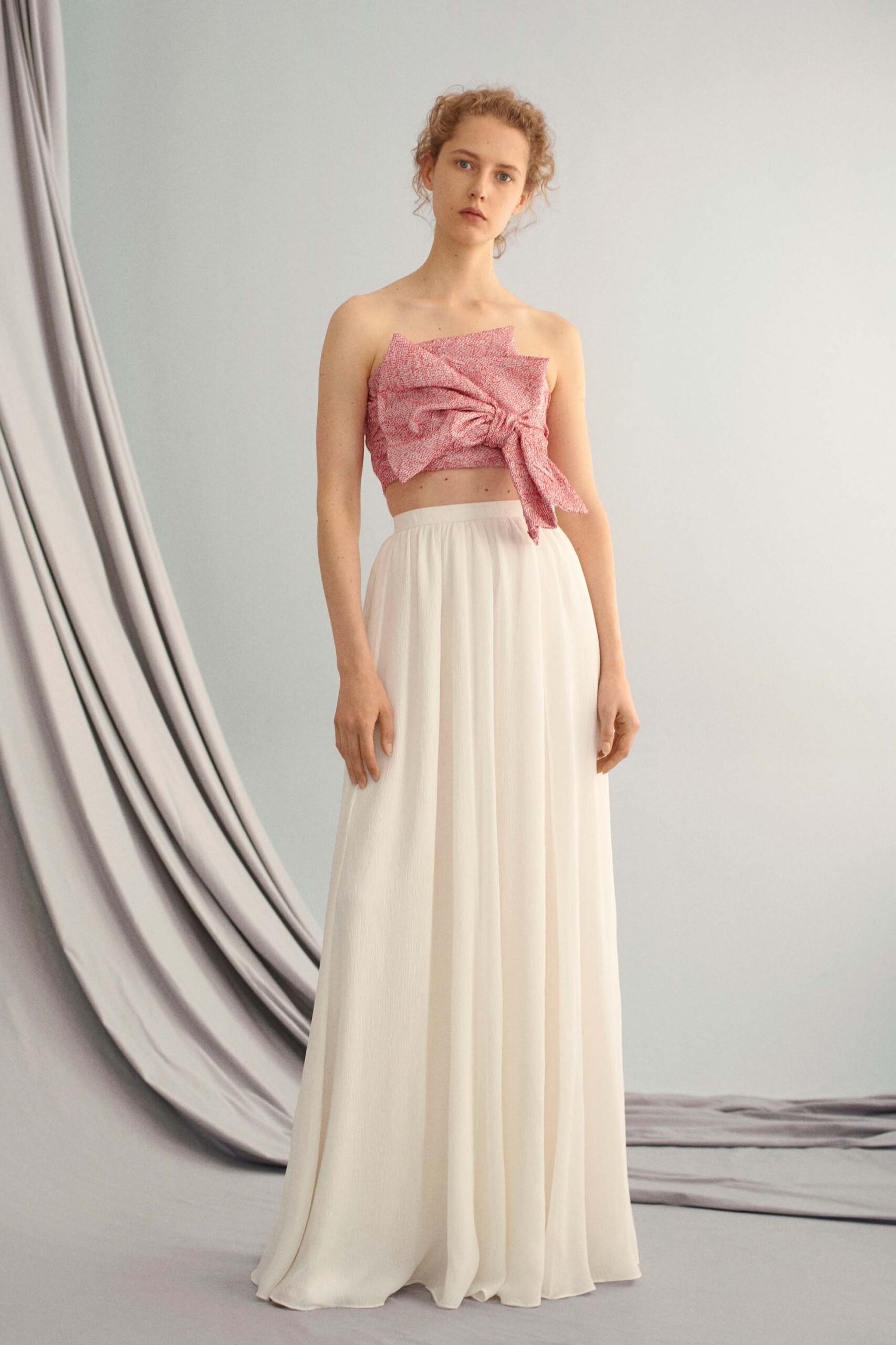 pink silk off-shoulder top and white tiered skirt