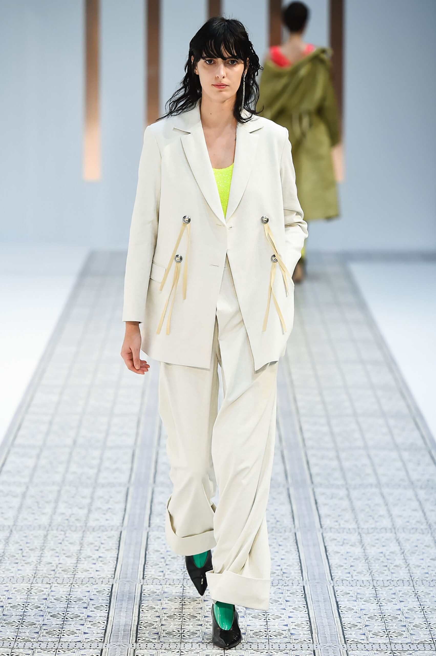 A relaxed beige cotton suit with long sleeves and wide-leg trousers, featuring a collared design.