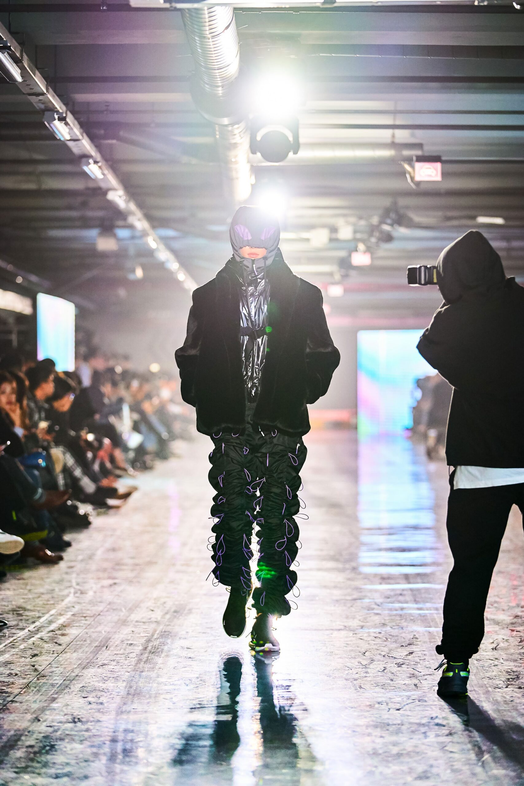 A relaxed black leather jacket paired with zippered pants for a stylish runway look.