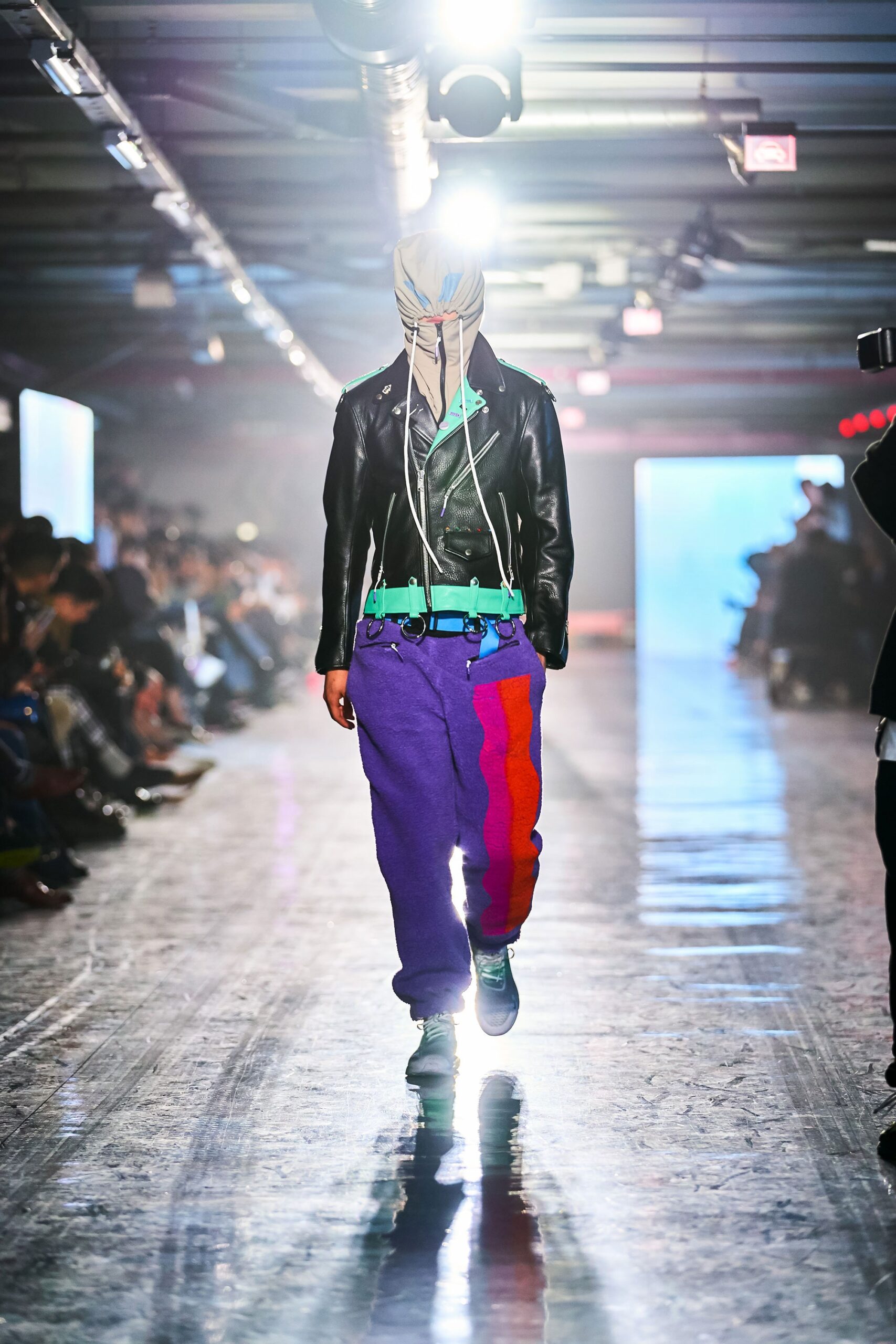 A relaxed black leather jacket paired with color-blocked cotton pants in purple and orange.