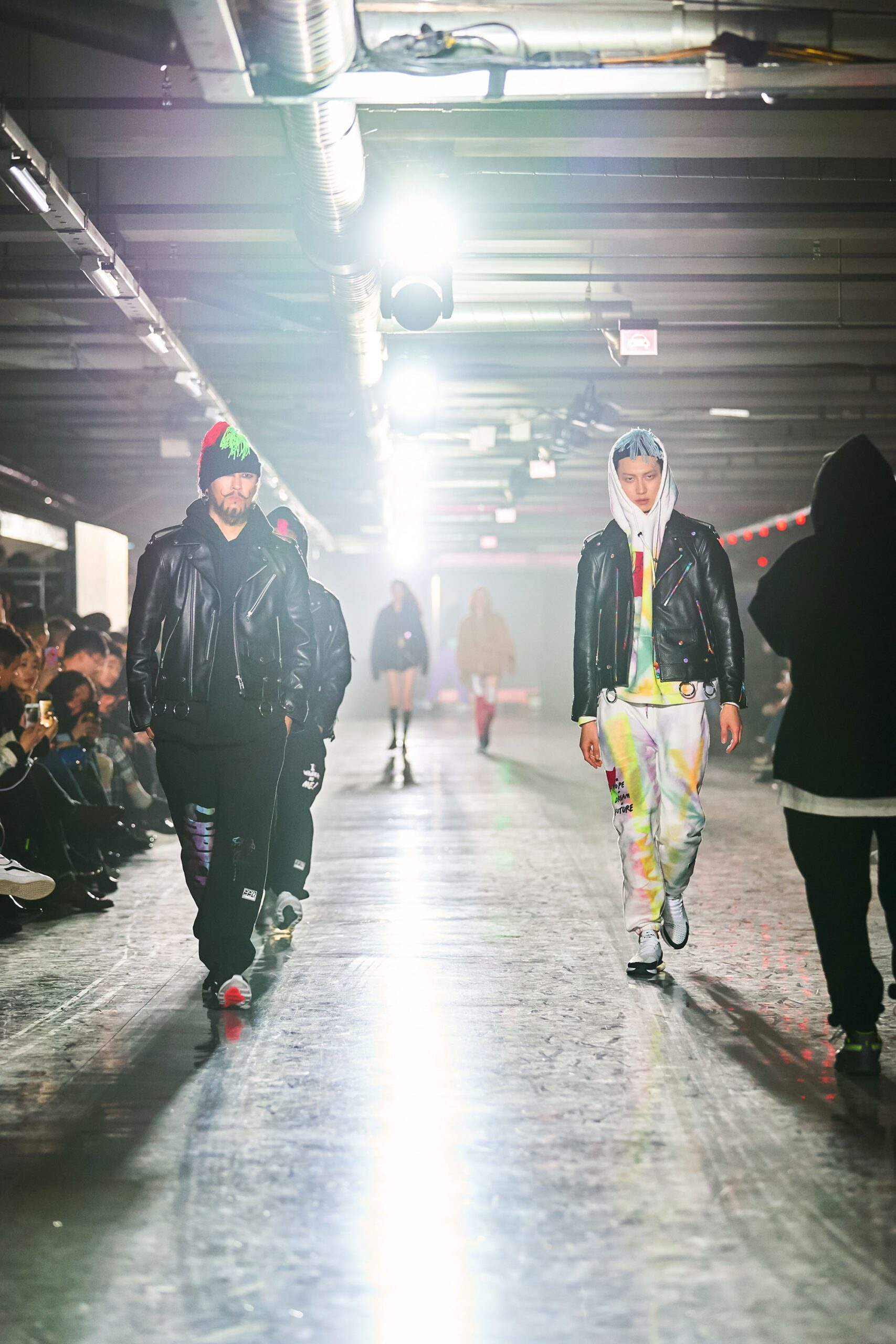 A fitted black leather jacket paired with multicolor printed pants, featuring a collared design.