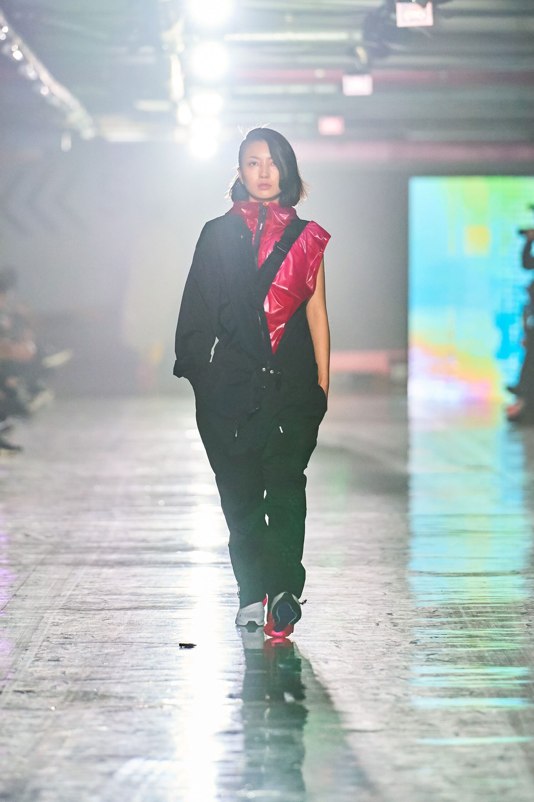 A relaxed black and red jumpsuit with a long-sleeve collar and asymmetric design.