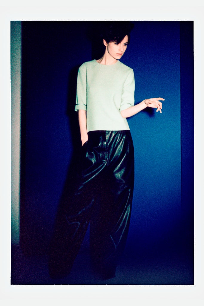 green relaxed top and black leather pants