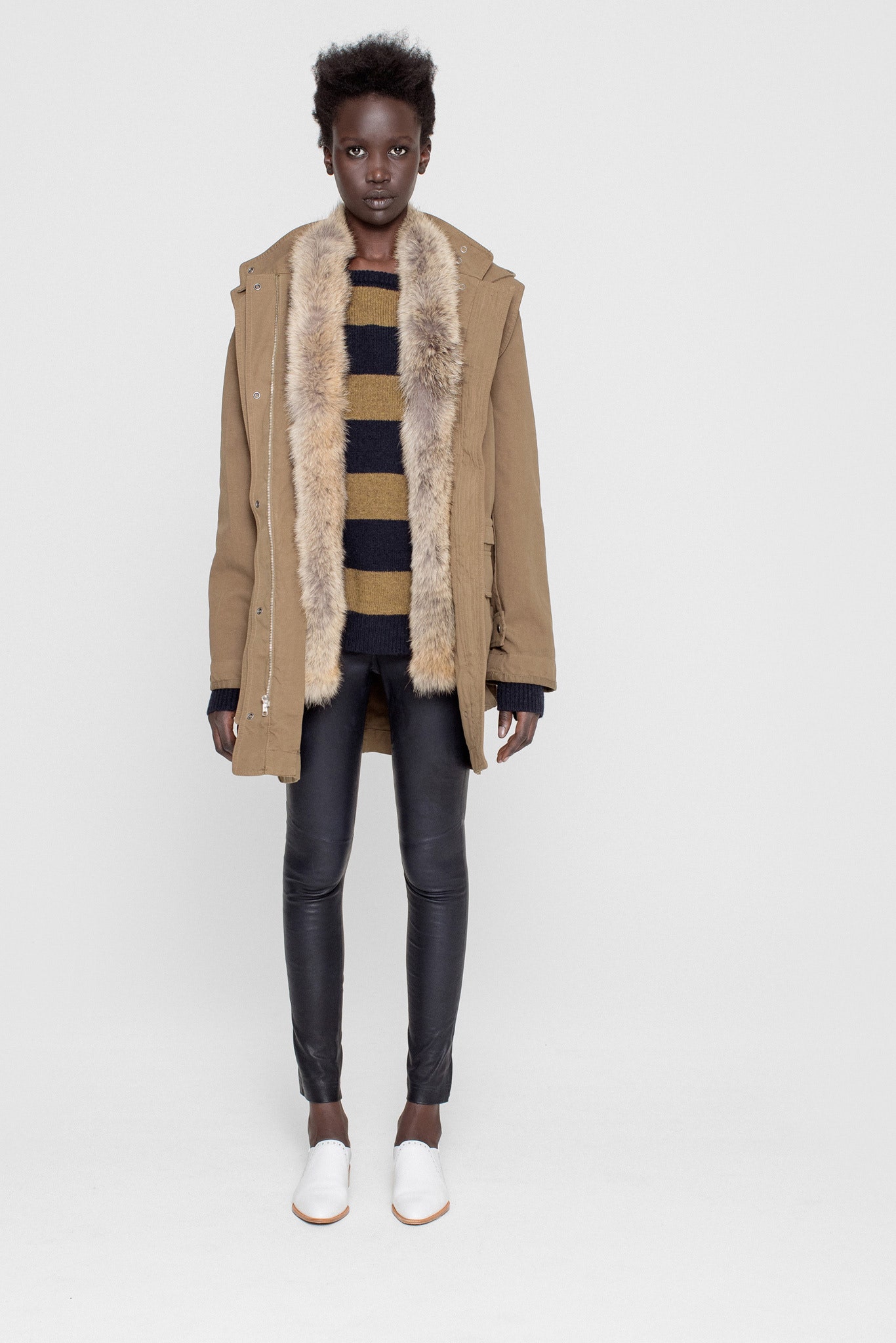 beige faux-fur coat with black striped sweater