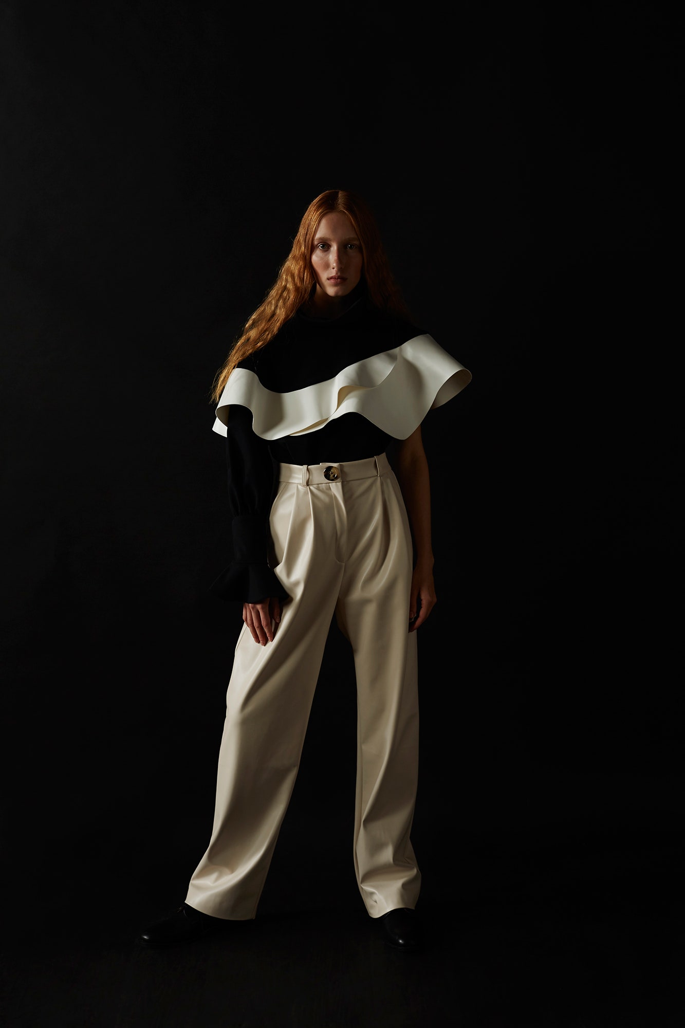 black and white ruffled top with beige pants