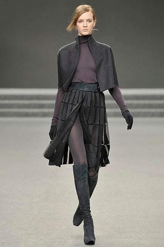 black wool cape and pleated skirt