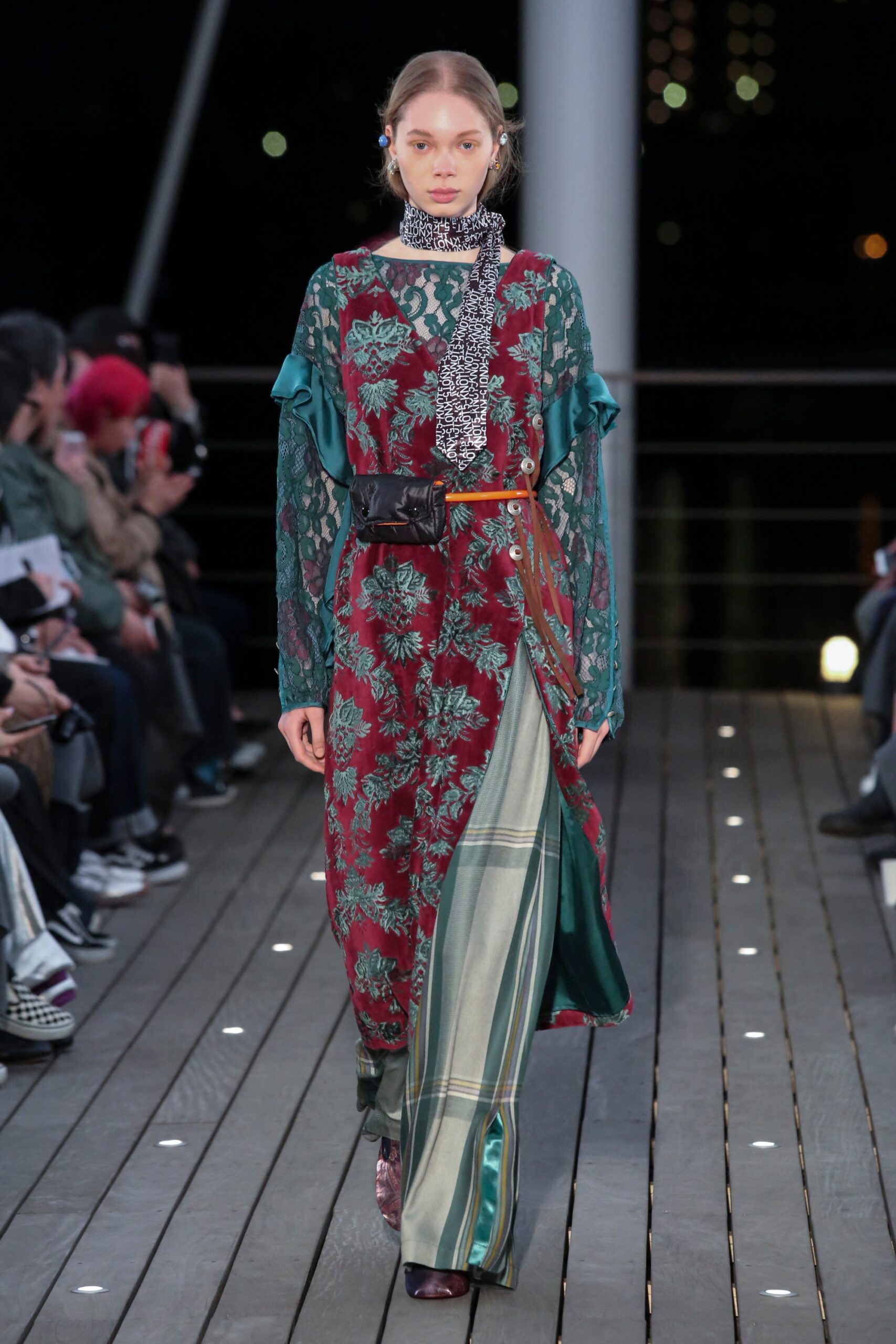 A relaxed red and green dress with long sleeves and a V-neckline featuring a flared silhouette.