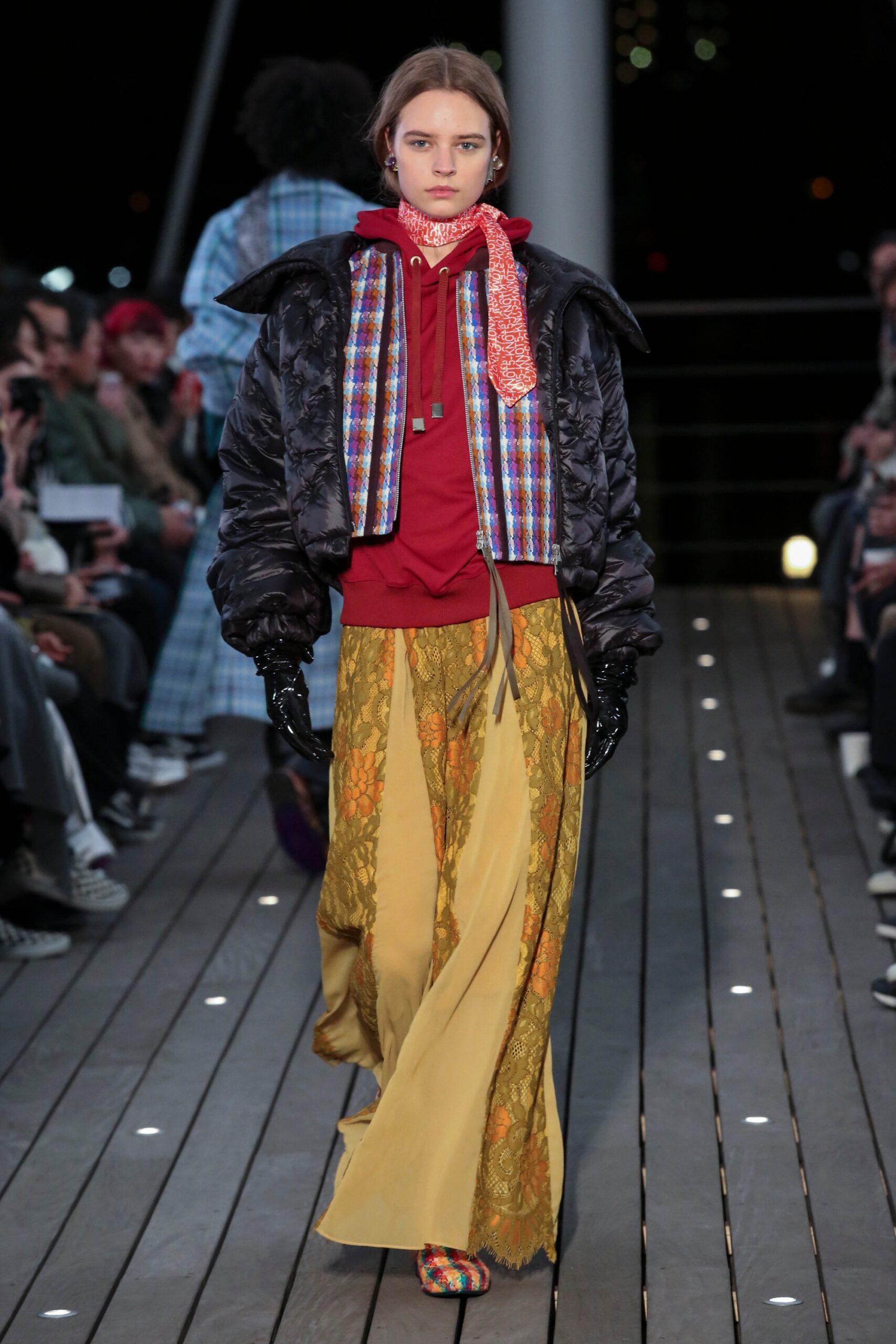 A relaxed black jacket paired with flared yellow pants, featuring a layered design.