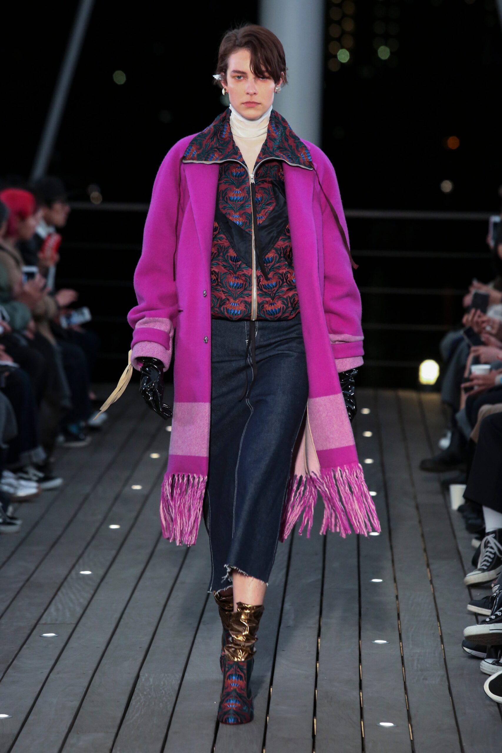 A relaxed purple coat with fringed details paired with printed blue pants.
