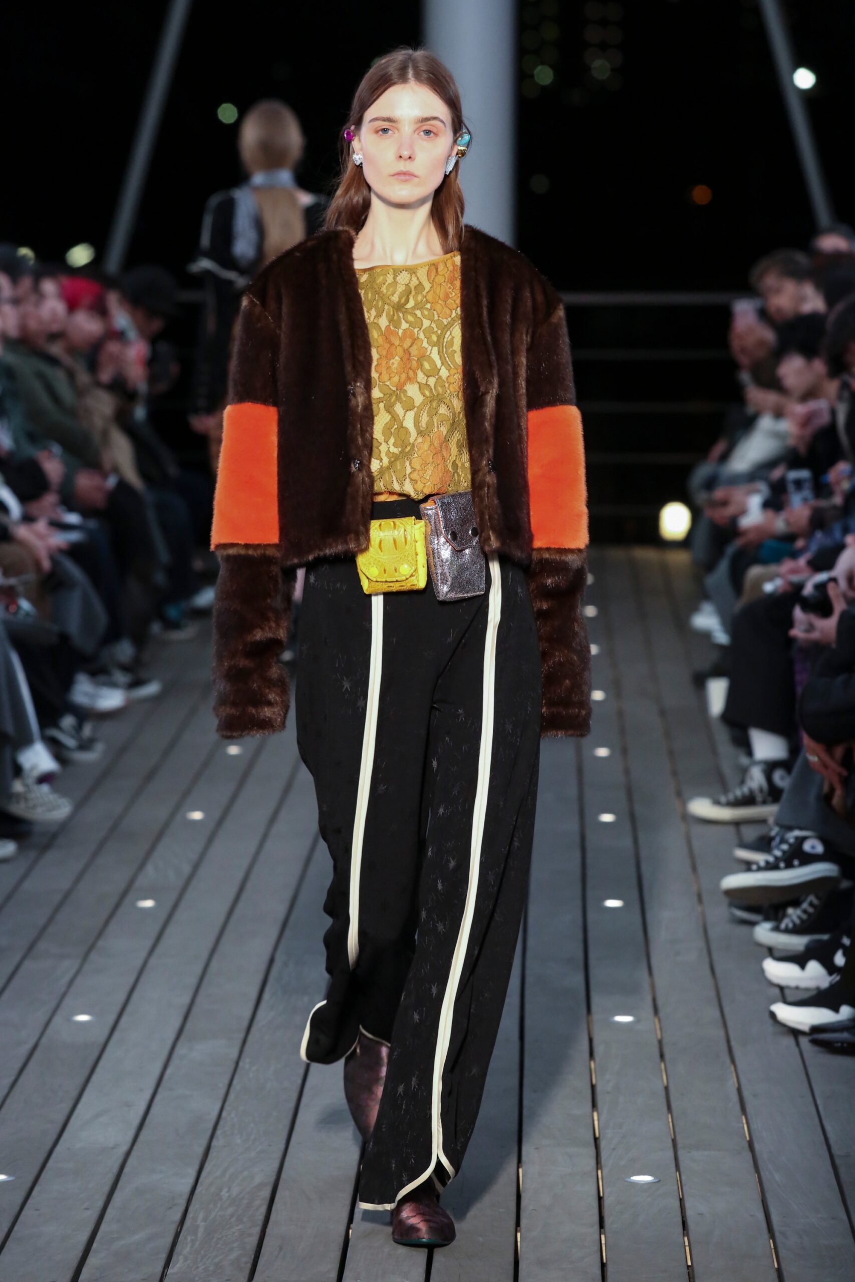 A relaxed brown fur jacket paired with silk pants featuring a layered design.